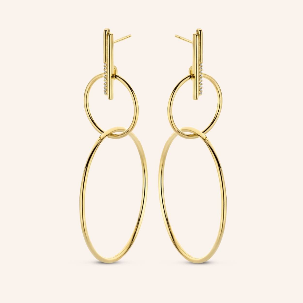 Double interlaced hoops, referring to aerial acrobatics, are hung on trapeze studs, featuring 18x bright white diamonds. Thanks to their captivating movement and dynamics, expect to be taken center stage.