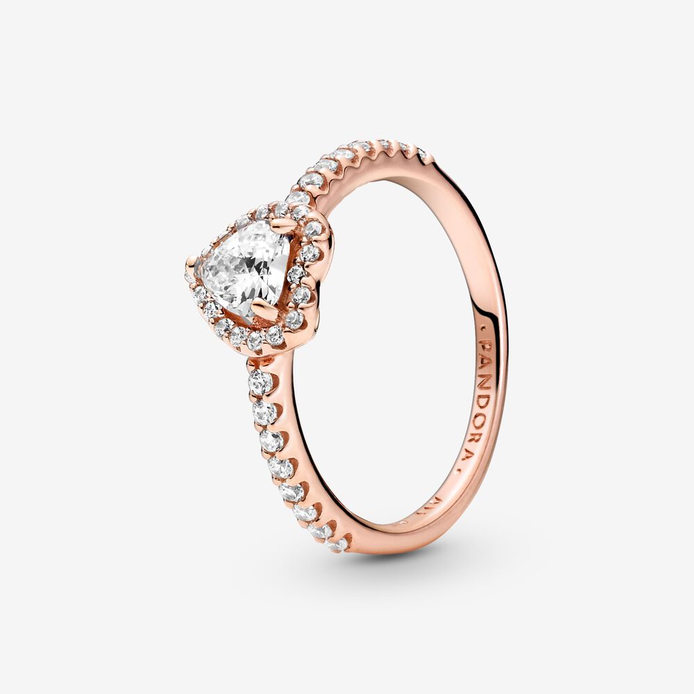 Geef je look een elegante finish met de Sparkling Elevated Heart Ring. De ring laat zich inspireren door de klassieke Pandora Timeless Collection. Dit stuk is hand-finished in Pandora Rose (onze unieke met 14k roségoud vergulde metaalcombinatie) en heeft een heldere hartvormige steen die verhoogd in het midden is gezet. Heldere stenen creëren een halo en versierden de helft van de ringband. Aan de binnenkant van de band is het Pandora-logo gegraveerd. Stapel deze ring met andere stijlen die hand-finished zijn in sterlingzilver voor een statement look van mixed metalen.