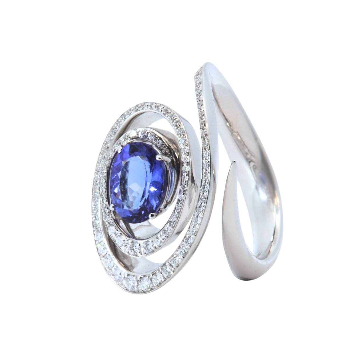 Witgouden ring met diamenten , spiraal met diamenten  en centraal een ovale blauwe tanzaniet edelsteen.