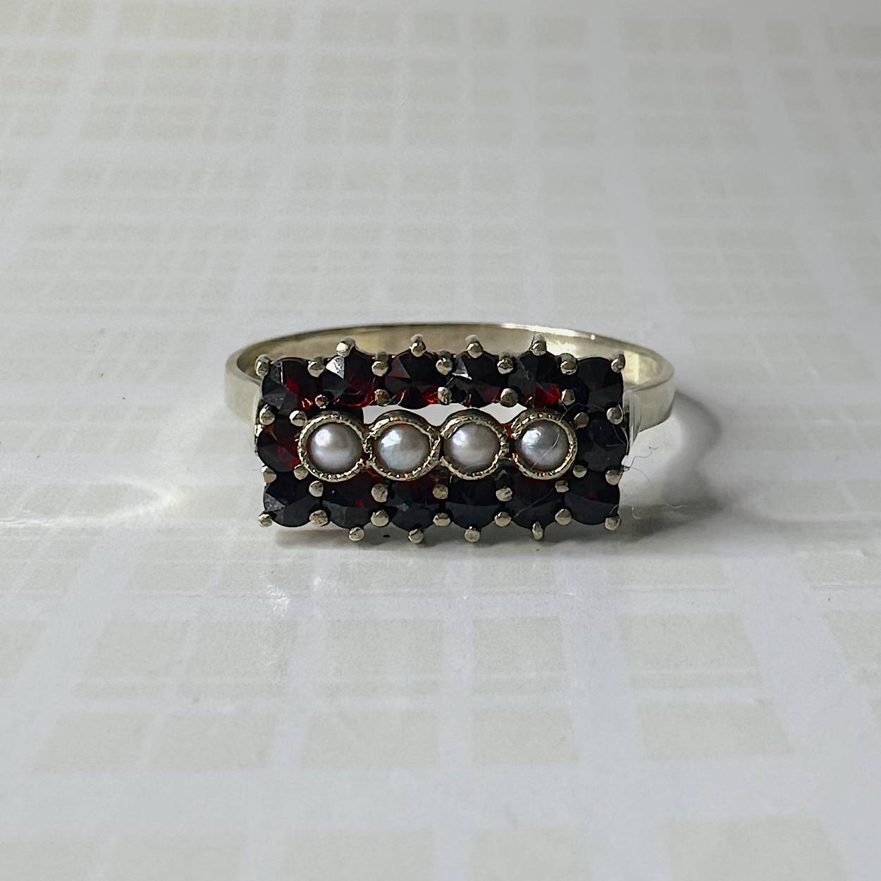 Deze prachtige vintage gouden ring is uitgevoerd met veertien briljant geslepen robijnen en vier parels. De ring is beschikbaar op maat 69.