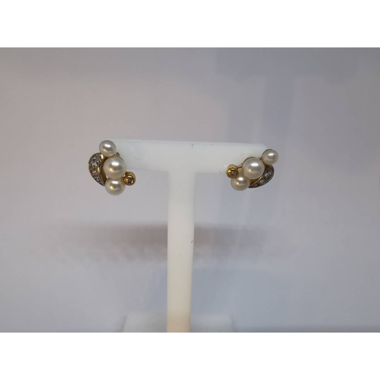 14 Karaat geel gouden oorstekers met parels in drie maten en diamanten in kastzetting en pavé zetting.