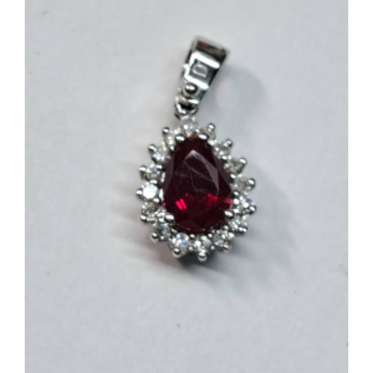 14 Karaat wit gouden entourage hanger bezet met robijn en briljant geslepen diamant 16x0.02 ct. 
Ook als set te kopen met oorringen €1495