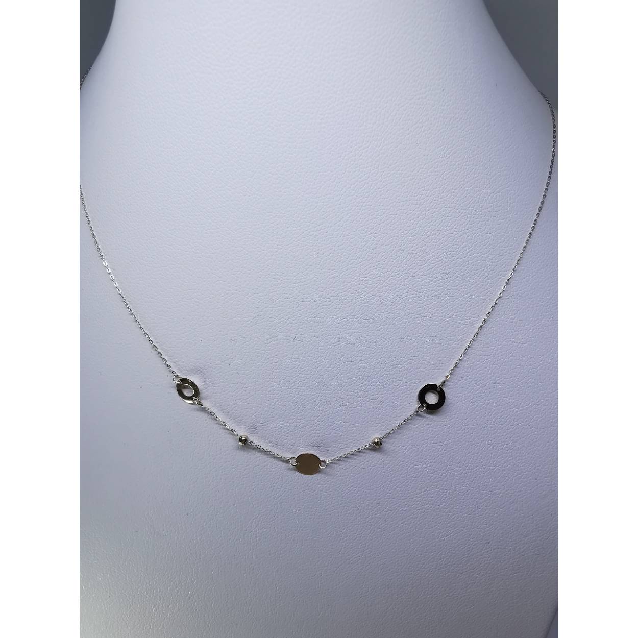 14 karaat geel gouden fijne schakel collier met twee doreka kraaltjes en drie cirkels waarvan twee opengewerkt en een dicht ertussen verwerkt.

0.94 gram
43 - 45 cm lang (verstelbaar)