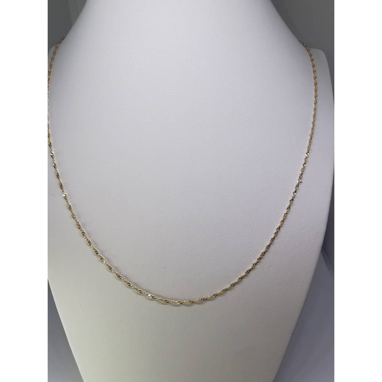 14 Karaat geel gouden Singapore collier. Een Singapore ketting bestaat uit een reeks platte diamant geslepen ruitvormige schakels. Vervolgens worden deze ruitvormige schakels gedraaid en afgeplat om een ketting te vormen. Dit proces resulteert in een ketting met schakels die licht reflecteren vanuit verschillende hoeken, waardoor de ketting een sprankelend uiterlijk krijgt en een aangename natuurlijke ronding. Leuk te combineren met een gouden hanger uit onze assortiment! 