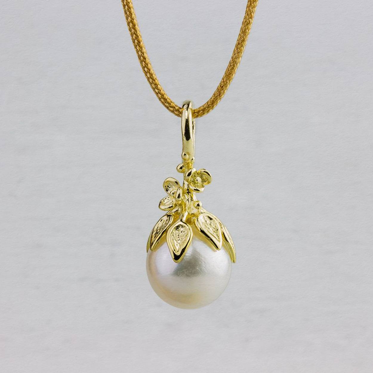 14k Geelgouden hanger met een florale afwerking en een witte ronde zoetwater parel.
Exclusief collier
