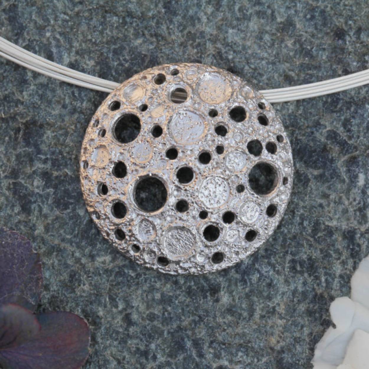 Bijzondere ronde en zilveren hanger van sterling zilver, doorsnee 3,5cm, zonder ketting. De hanger heeft kleine en grotere gaatjes die mooi schitteren door de diamantering. Een bijpassende armband, oorbellen en ring zijn ook verkrijgbaar. Het afgebeelde collier (TA0519003.45) kost €89,-