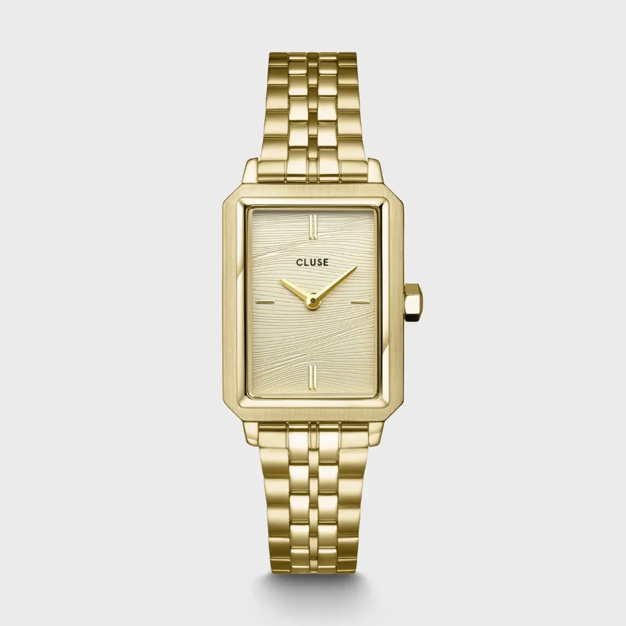 Voeg een gevoel van luxe en verfijning toe aan je look met het Fluette dameshorloge. Met een gepolijste goudkleurige rechthoekige horlogekast van 30,6 mm, een roestvrijstalen horlogeband van 14 mm met schakels en een goudkleurige wijzerplaat met zandstructuur die doet denken aan de warmte van zomers zand. Pas gemakkelijk de look van je horloge aan met een horlogebandje van 14 mm.