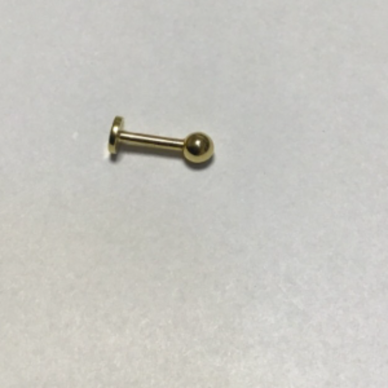 18 krt gouden onderlip piercing.