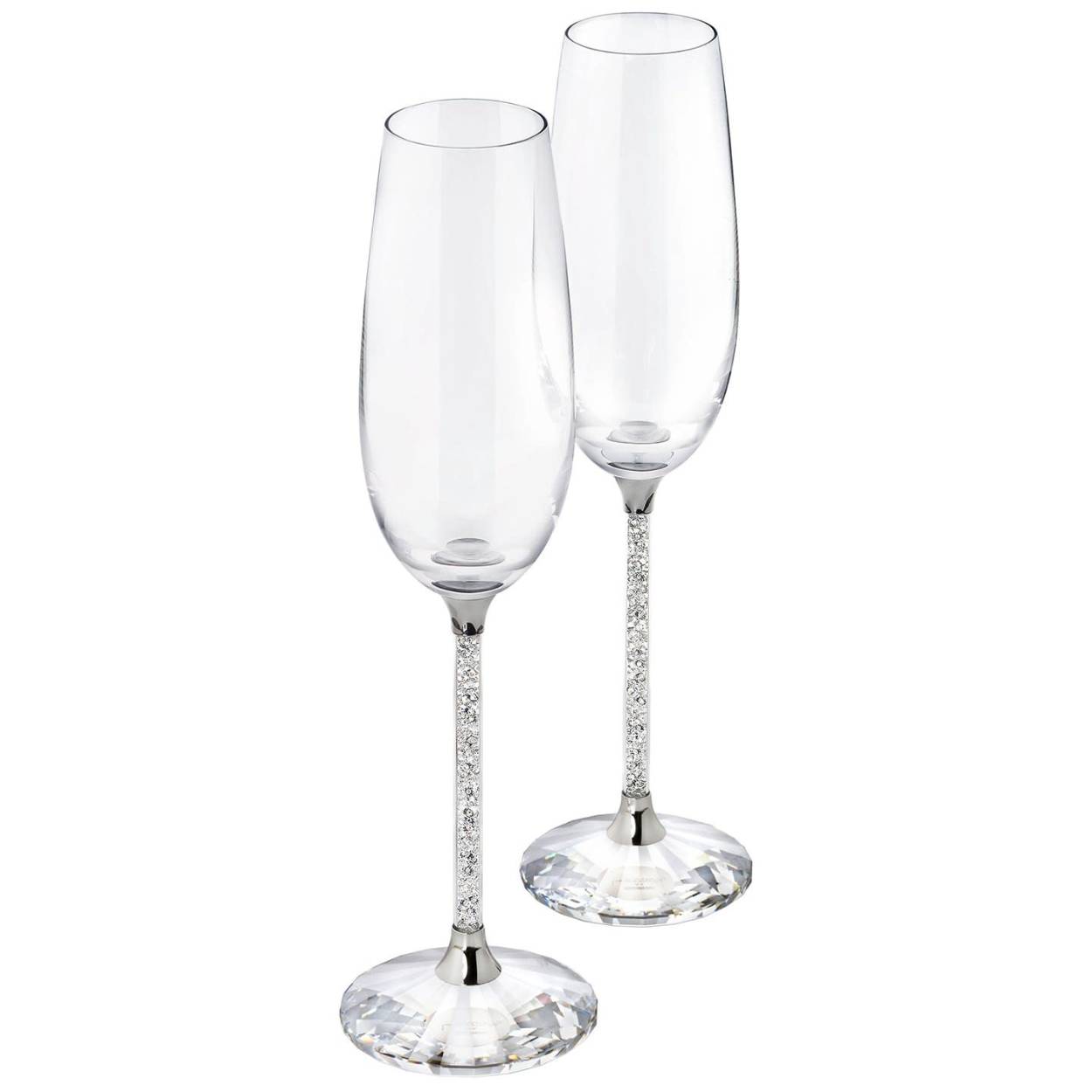 Deze delicate, elegante en zeer feestelijke set van twee flûtes is voor zeer speciale gelegenheden. Het heldere kristal dat de stelen vult en de gefacetteerde heldere kristallen basis van elke flûte voegt een element van romantiek toe aan elke avond waardoor deze iets specialer wordt. Decoratieobject. Geen speelgoed. Niet geschikt voor kinderen jonger dan 15 jaar.