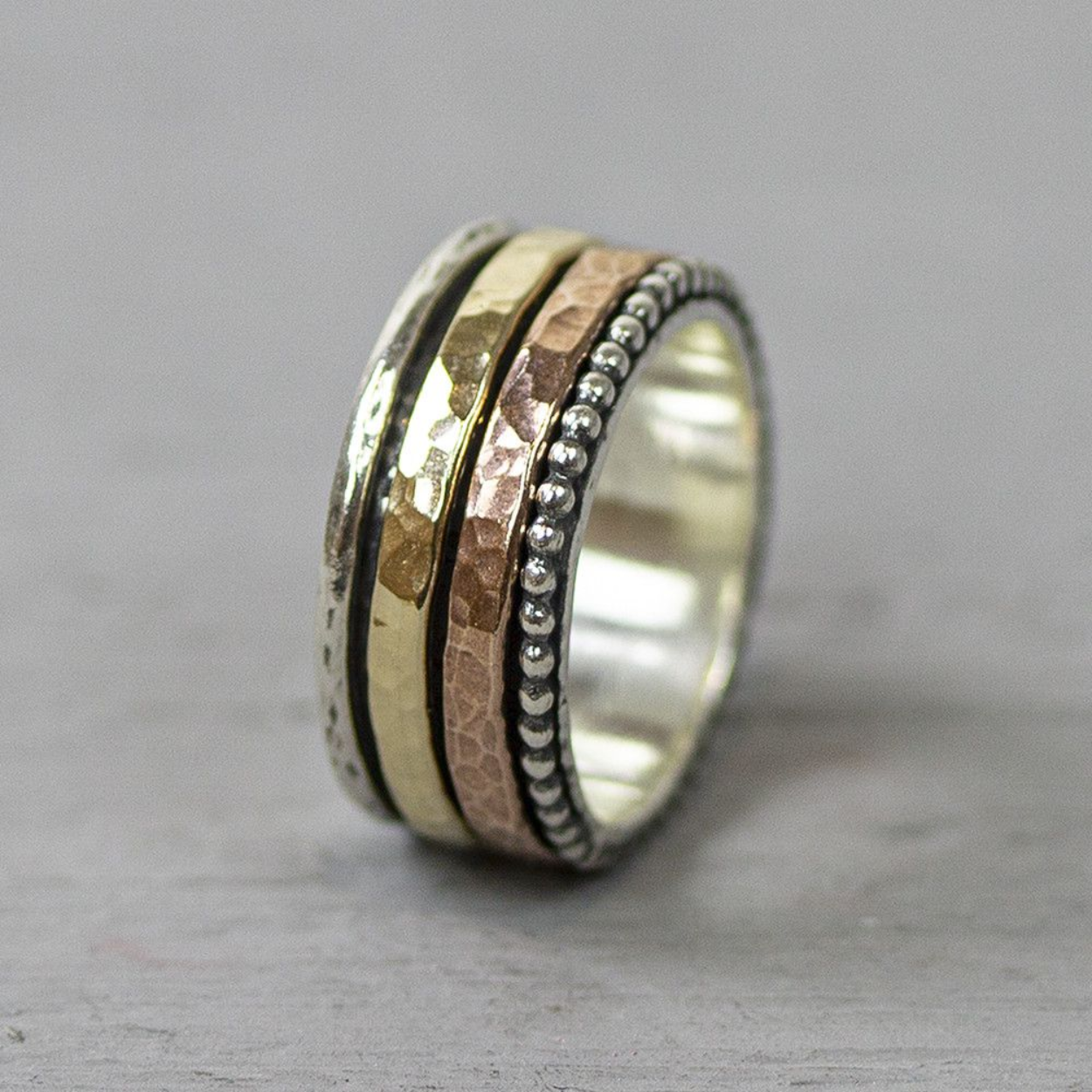 Ring gemaakt van 925 sterling zilver met een dubbele goldfilled band. De twee kleurige goldfilled ringetjes om deze ring kunnen draaien, maar kunnen niet verwisseld worden. Dit is de eerste ring waarbij er met zowel goud als rose goldfilled is gewerkt! De glans van 925 sterling zilver maakt het een gewild edelmetaal voor de vervaardiging van sieraden. Het bestaat uit 92,5% puur zilver en 7,5% koper. Puur zilver is een zacht en buigzaam materiaal, het koper in 925 sterling zilver zorgt voor de stevigheid. De sieraden van Jéh Jewels zijn nikkel vrij. Op dit sieraad is gebruik gemaakt van geoxideerd zilver, dit is een oppervlakte bewerking. Het is mogelijk dat de geoxideerde laag na verloop van tijd door slijtage vervaagd. Goldfilled komt uit Amerika en wordt daar al langer gebruikt voor de vervaardiging van sieraden met een "touch of gold" voor een betaalbare prijs. Het goldfilled blijft op kleur, is slijtvast en de goudlaag is dik genoeg om lang te kunnen genieten van de warme uitstraling van goud. Goldfilled wordt veelal ook goed verdragen door mensen die allergisch zijn voor andere metalen dan goud.