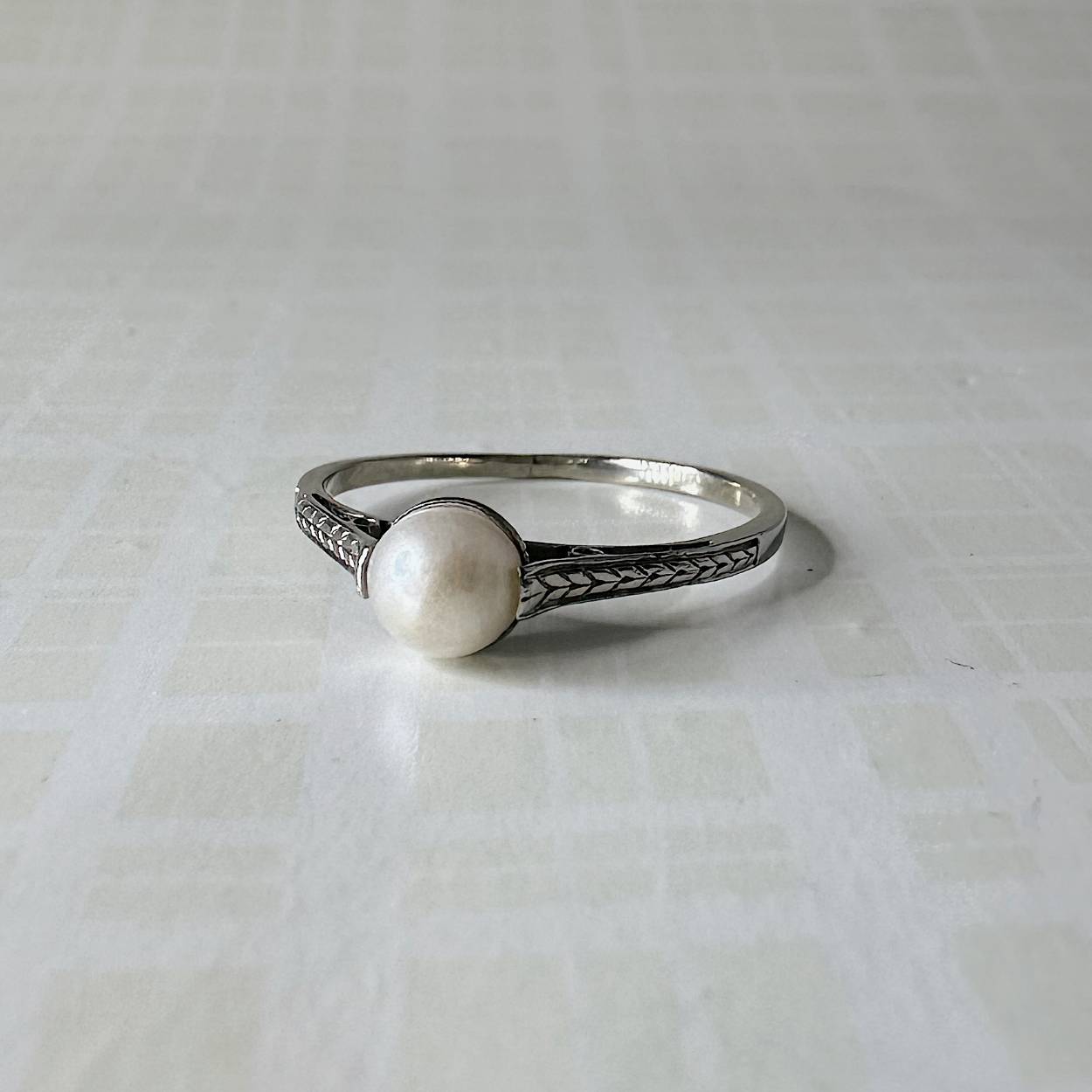 Deze prachtige witgouden ring is uitgevoerd met een zoetwaterparel en heeft aan de zijkant een decoratieve afwerking. De ring is beschikbaar op maat 53.