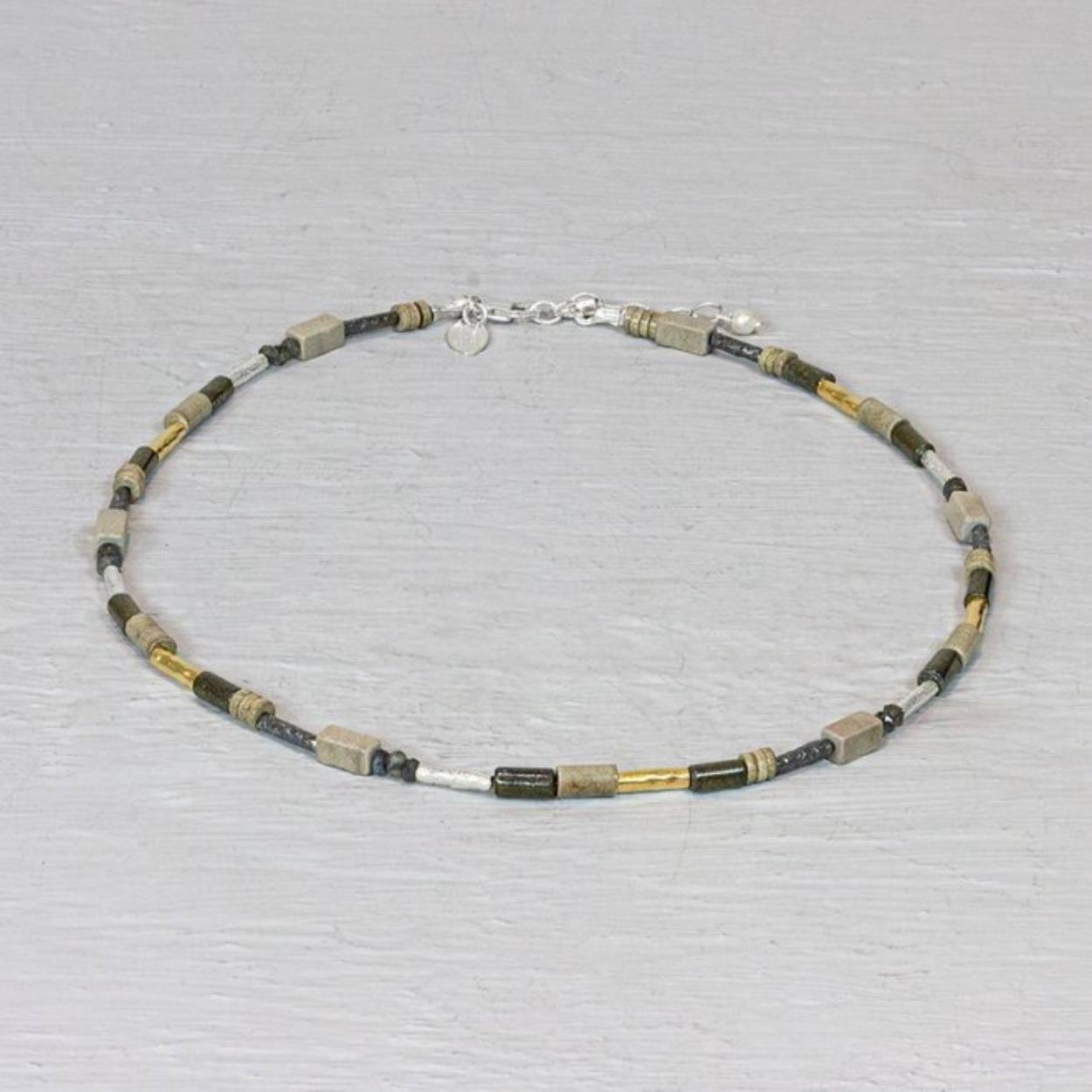 Collier van Jeh Jewels met buisjes en edelstenen. Dit collier is gemaakt van buisjes van verschillende materialen. Er is zowel zilver, geoxideerd zilver en goldfilled gebruikt. Verder is dit collier aangevuld met de verschillende edelstenen: Howliet, Labradoriet en Pyriet.