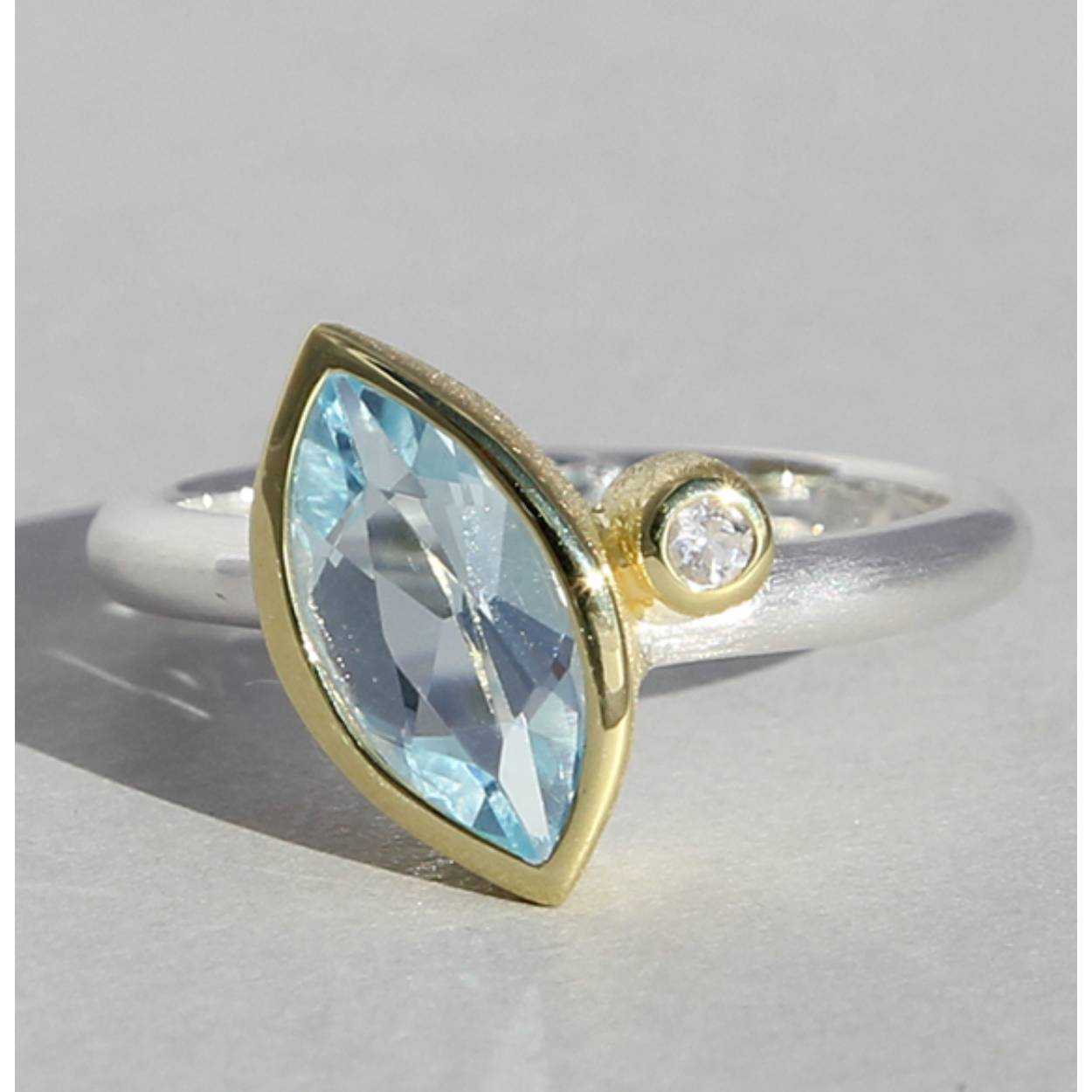 Zilveren ring met topaas en bergkristal in vergulde zetting.