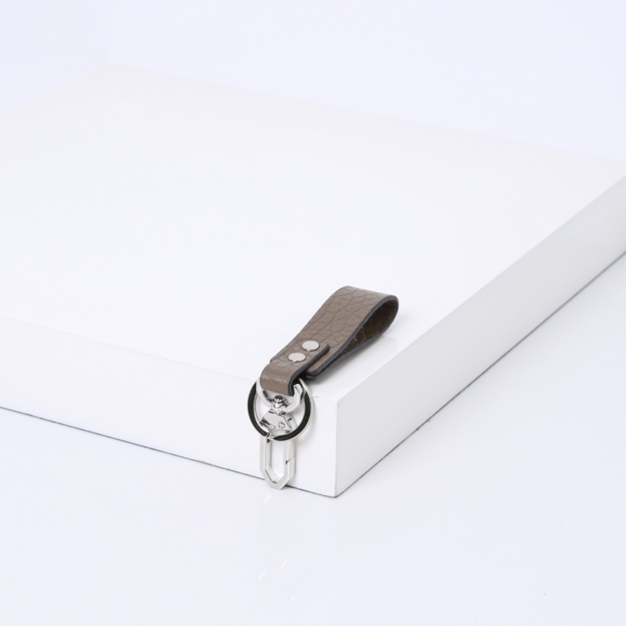 De SMAAK KEYCHAIN is verkrijgbaar in zacht soepel rundleer en stevig rundleer met een reliëfpatroon van olifantenhuid.
 
Uniek aan deze klassieke sleutelhanger is dat deze naast de ring een extra haakje bevat met een subtiel logo erin gegraveerd. Zo kun je de sleutelbos gemakkelijk vastklikken aan bijvoorbeeld je tas of riemlus.
 
Een must-have voor jezelf, maar ook leuk om cadeau te geven!