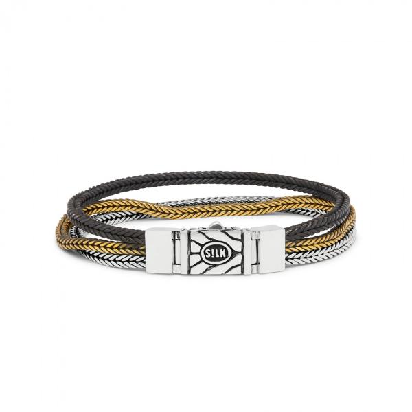 Met de RAW Editions sieraden heeft SILK een nonchalante look weten te creëren door het gebruik van nieuwe materialen in de handgemaakte sterling zilver collectie. Elk SILK-sieraad doorloopt een uitgebreid vakmanschapsproces, resulterend in unieke massieve sterling zilveren ontwerpen voor rauwe mannen en vrouwen. Met de RAW editions introduceert SILK een aantal sterling zilveren armbanden gecombineerd met messing en zwart oxide, waarvoor speciale borsteltechnieken gebruikt werden voor een ‘worn style’ uiterlijk. De RAW editions ontwerpen zijn handgemaakt van pure metalen, messing en sterling 925 zilver. 



Deze 284 RAW edition bi-color armband bevat naast 925 sterling zilver ook het niet edele metaal; messing. Deze armband heeft daardoor een twee kleurig uiterlijk. De bi-color armbanden geven door de messing kleur een gevoel van luxe en een soort ruwheid te gelijk.



Alle RAW editions armbanden zijn "made to fade", wat betekend dat het messing naar verloop van tijd van kleur kan veranderen. Je armband zal ook krassen en vervagen op een manier die je eigen verhaal verteld. Juist deze RAW worn-style look is wat deze armbanden zo uniek maakt!



Tof detail aan deze armband is dat deze sluit middels een omkeerbaar structuur slot, welke daardoor aan twee zijde gedragen kan worden, desgewenst met het logo naar voren of met het logo naar binnen.