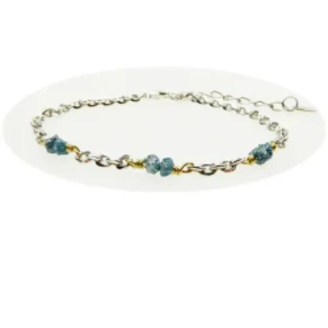 Armband en ketting in gerhodineerd sterling zilver met vergulde twists en 3x2 blauw-groenachtige ruwe diamanten.

De armband is met 4cm verlengkettinkje en de ketting met 8cm verlengkettinkje.

De ketting is aan alle kanten gediamanteerd / gefacetteerd, daarom veel glanzender / glinsterender dan gewone ankerkettingen - zeer spannende look
