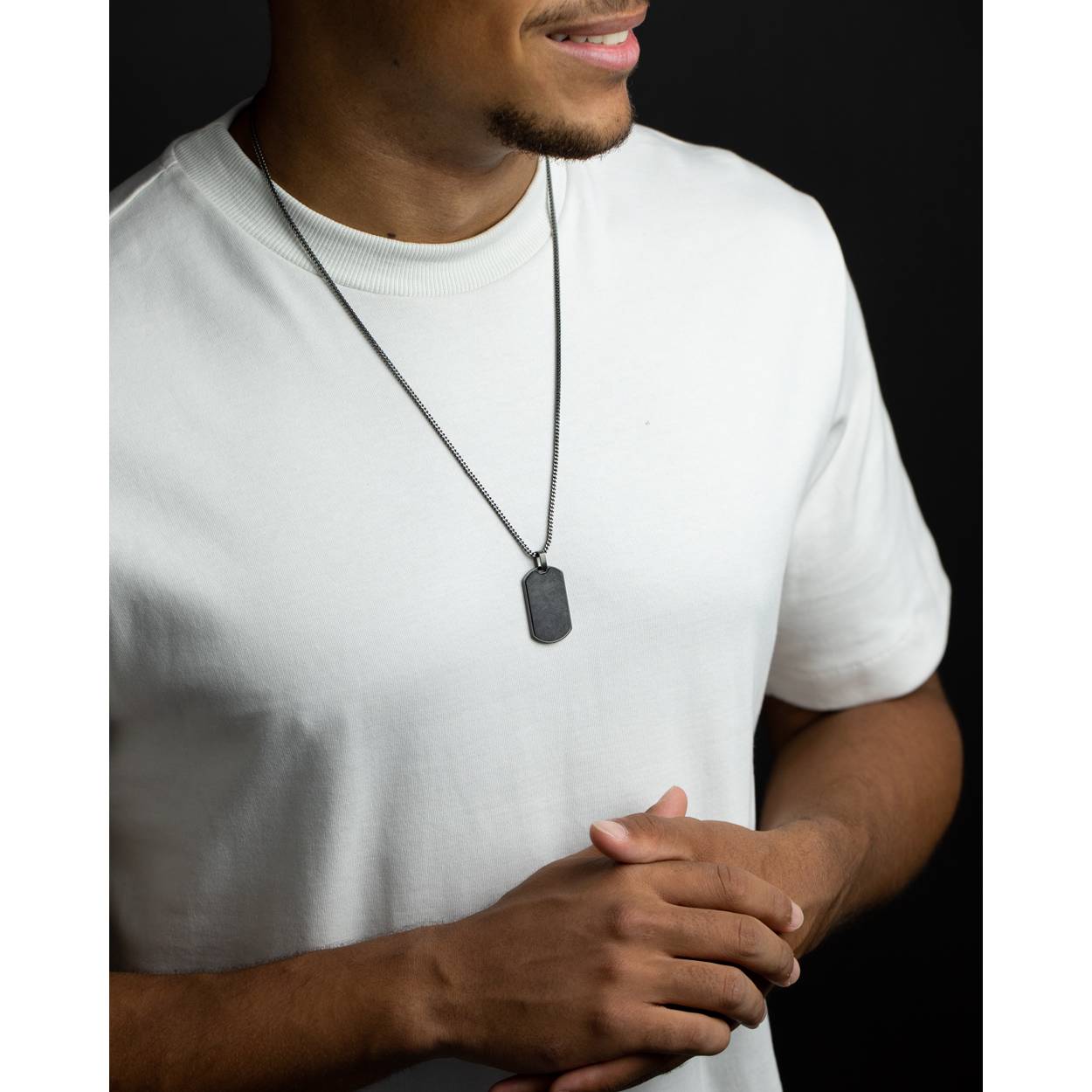  Deze Bellum Black-ketting is gemaakt met een donkergekleurde vossenstaartketting van 2 mm en heeft een hanger met gesmede koolstofvezel. De Latijnse naam 'Bellum' betekent 'oorlog' en verwijst naar de vorm van de ketting die vaak door moderne soldaten wordt gedragen.

De ketting is 58 cm lang en wordt geleverd met een verlengkettinkje van 6 cm, waardoor je zeker weet dat je altijd een maat hebt die past.

De hanger is afgewerkt met echt gesmeed koolstofvezel, een exclusief materiaal dat ook wordt gebruikt in supercars, motorboten en ruimtevaart. De verhouding tussen vermogen en gewicht is buitengewoon en hij is gemaakt van koolstofvezelstrengen die onder hoge druk worden gevormd. Dit geeft de koolstofvezel hanger zijn zilver-grijs-zwarte tinten.

Waarom zou je er een kopen?

- Je ketting wordt binnen 72 uur gemaakt en verzonden.
- Het is gemaakt van hoogwaardige materialen.