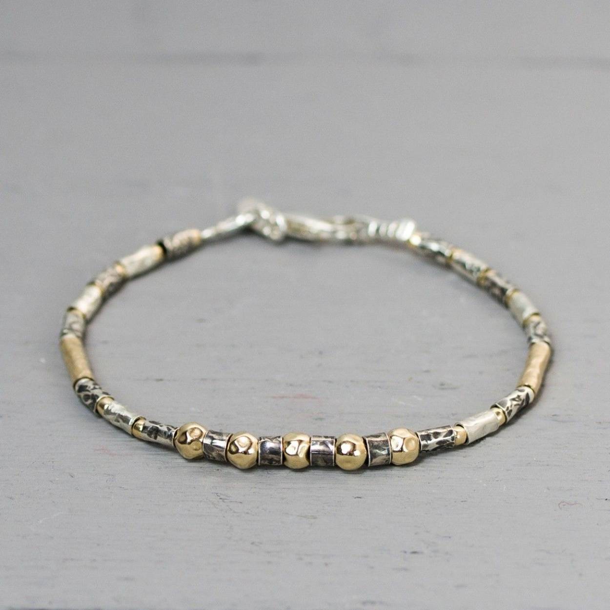 Een nieuwe armband in de serie wat wij 'buisjes" armbanden noemen. Deze armband is gemaakt van 925 sterling zilver, geoxideerd zilver en Goldfilled. De glans van 925 sterling zilver maakt het een gewild edelmetaal voor de vervaardiging van sieraden. Het bestaat uit 92,5% puur zilver en 7,5% koper. Puur zilver is een zacht en buigzaam materiaal, het koper in 925 sterling zilver zorgt voor de stevigheid. De sieraden van Jeh Jewels zijn nikkel vrij. Op dit sieraad is gebruik gemaakt van geoxideerd zilver, dit is een oppervlakte bewerking. Het is mogelijk dat de geoxideerde laag na verloop van tijd door slijtage vervaagd. Goldfilled komt uit Amerika en wordt daar al langer gebruikt voor de vervaardiging van sieraden met een "touch of gold" voor een betaalbare prijs. Het goldfilled blijft op kleur, is slijtvast en de goudlaag is dik genoeg om lang te kunnen genieten van de warme uitstraling van goud. Goldfilled wordt veelal ook goed verdragen door mensen die allergisch zijn voor andere metalen dan goud.