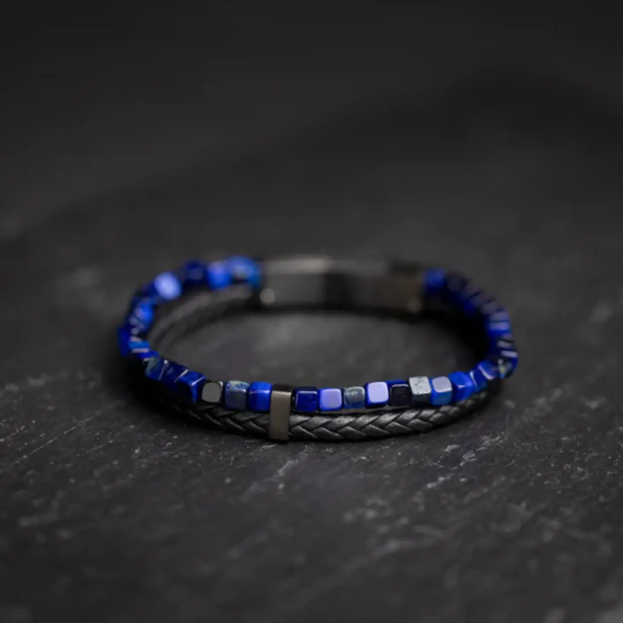 Het zwarte leer dat voor deze Double 3 Colours armband gebruikt wordt, is werkelijk uitzonderlijk: het is met de hand geweven in Toscane, Italië. Je zult duidelijk het verschil voelen met elk soort leer dat je ooit hebt geprobeerd.

De armband is afgewerkt met 3 verschillende blauwe kleuren Tijgeroogsteen. Tijgeroog wordt ook wel 'de steen der Krijgers' genoemd. Het is een krachtige steen die je beschermt tegen negatieve invloeden. Hij zou je extra moed, kracht en doorzettingsvermogen geven.