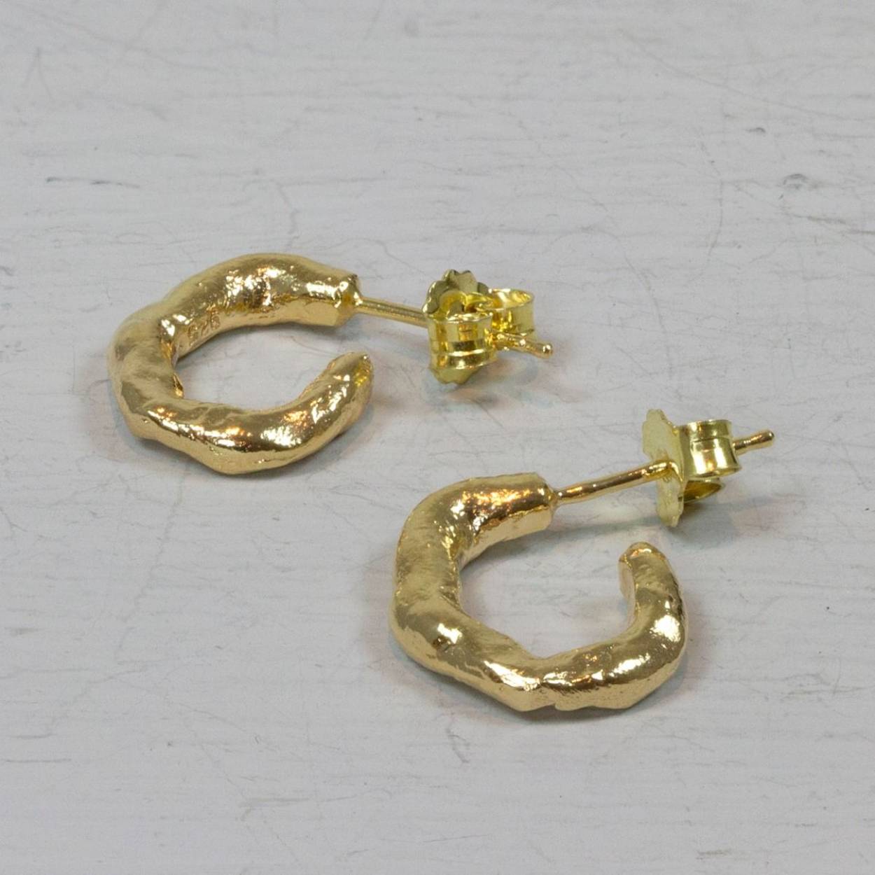 Deze Jéh Jewels oorstekers zijn gemaakt van 925 sterling zilver en zilver verguld in de vorm van een kleine organische lus.