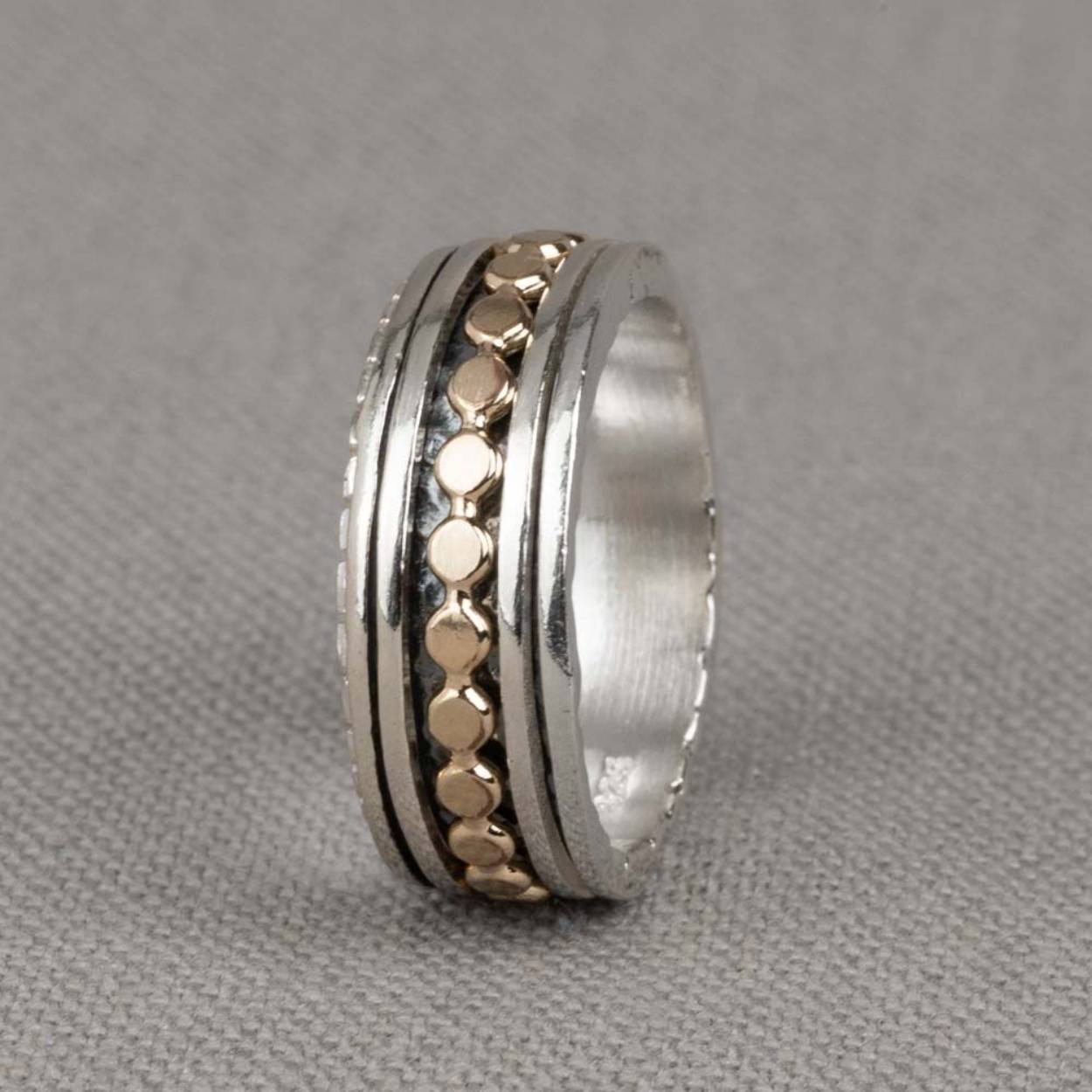 Deze ring is gemaakt van 925 sterling zilver en gold filled. De ring heeft drie losse ringetjes die afzonderlijk van elkaar kunnen bewegen. De ringetjes bestaan uit twee zilveren en één gold filled ringetje in de vorm van platte balletjes. De onderkant van de ring is geoxideerd wat zorgt voor extra diepte. 

Materiaal: Zilver
De glans van 925 sterling zilver maakt het een gewild edelmetaal voor de vervaardiging van sieraden. Het bestaat uit 92,5% puur zilver en 7,5% koper. Puur zilver is een zacht en buigzaam materiaal, het koper in 925 sterling zilver zorgt voor de stevigheid. De sieraden van Jéh Jewels zijn nikkel vrij.

Materiaal: Gold filled
Gold filled komt uit Amerika en wordt daar al langer gebruikt voor de vervaardiging van sieraden met een "touch of gold" voor een betaalbare prijs. Het gold filled blijft op kleur, is slijtvast en de 14karaats goudlaag is dik genoeg om lang te kunnen genieten van de warme uitstraling van goud. Gold filled wordt veelal ook goed verdragen door mensen die allergisch zijn voor andere metalen dan goud.