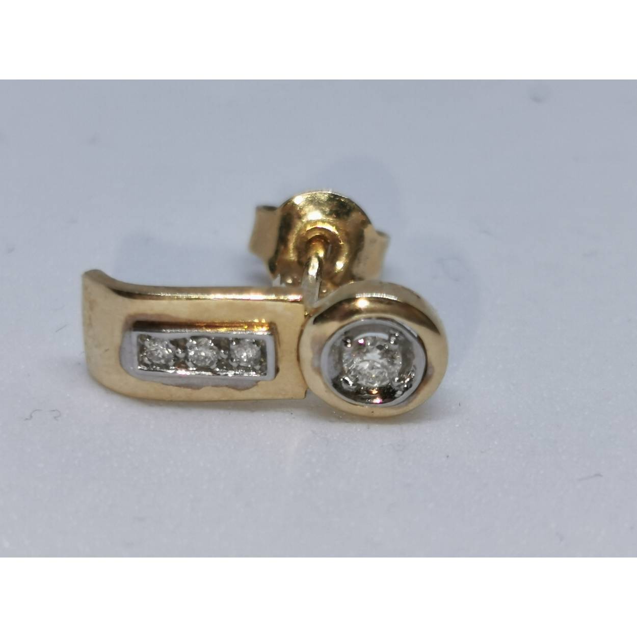 14 karaat bi color gouden oorstekers diamant

Center diamant briljant geslepen 0.10 crt D1
in kast zetting 
Omliggende diamanten briljant geslepen 0.05 crt D2
2.12 gram 