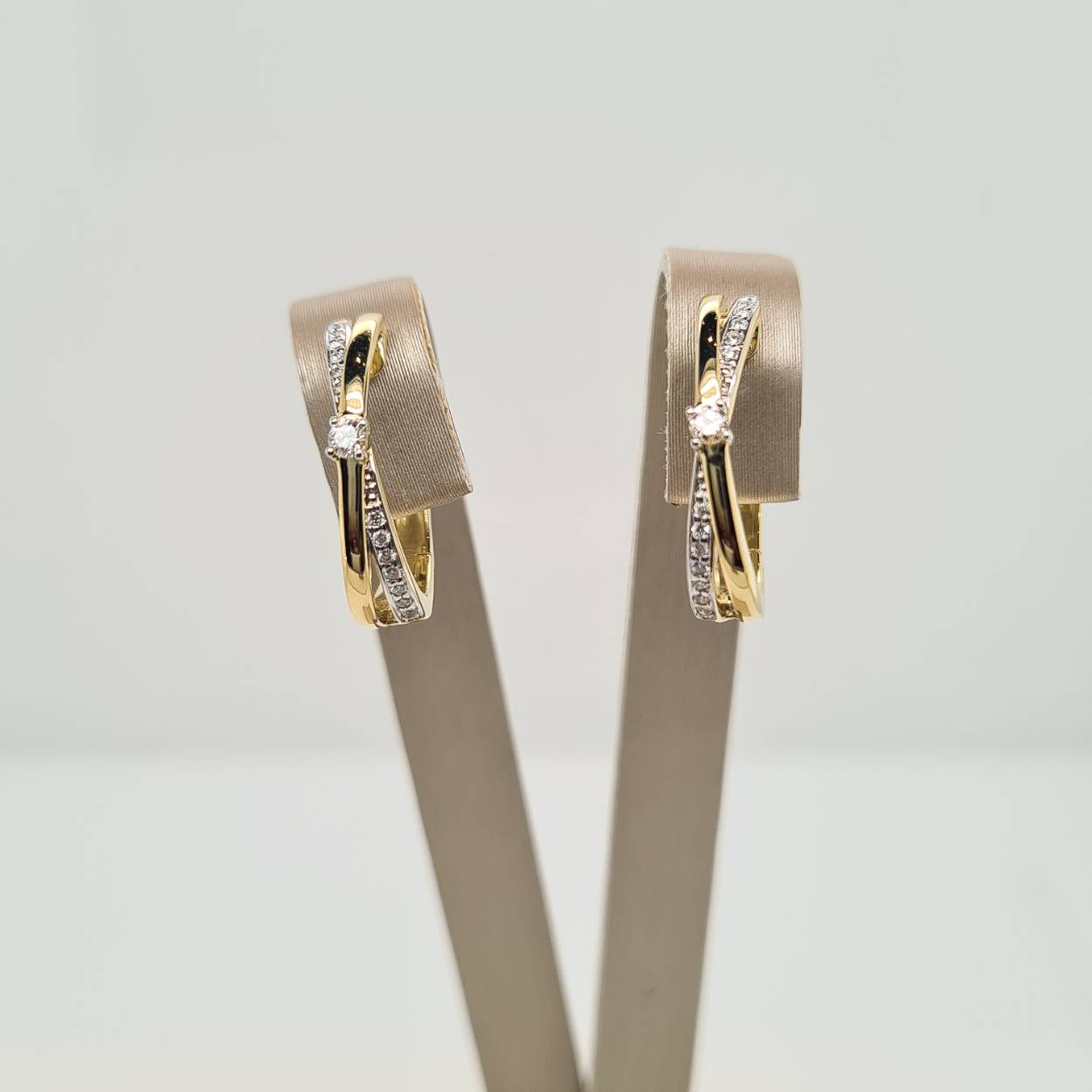 Prachtige 14 karaat gouden oorsieraden met een mooie rij diamanten en een diamant in het midden, 0.14crt. 