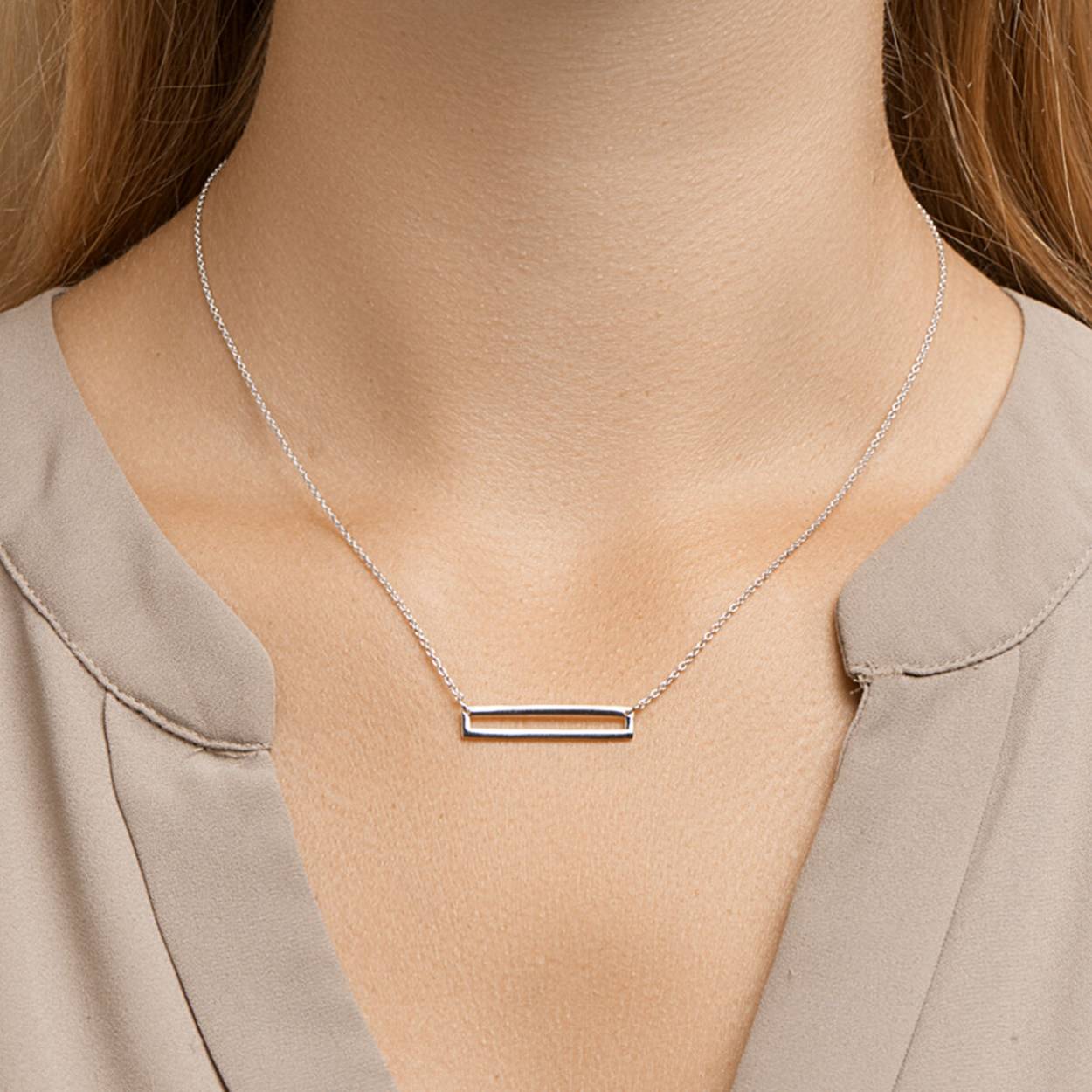 Deze ketting heeft een rechthoekig opengewerkt plaatje. De lengte van de ketting is te variëren tussen de 41 en 45 cm 
