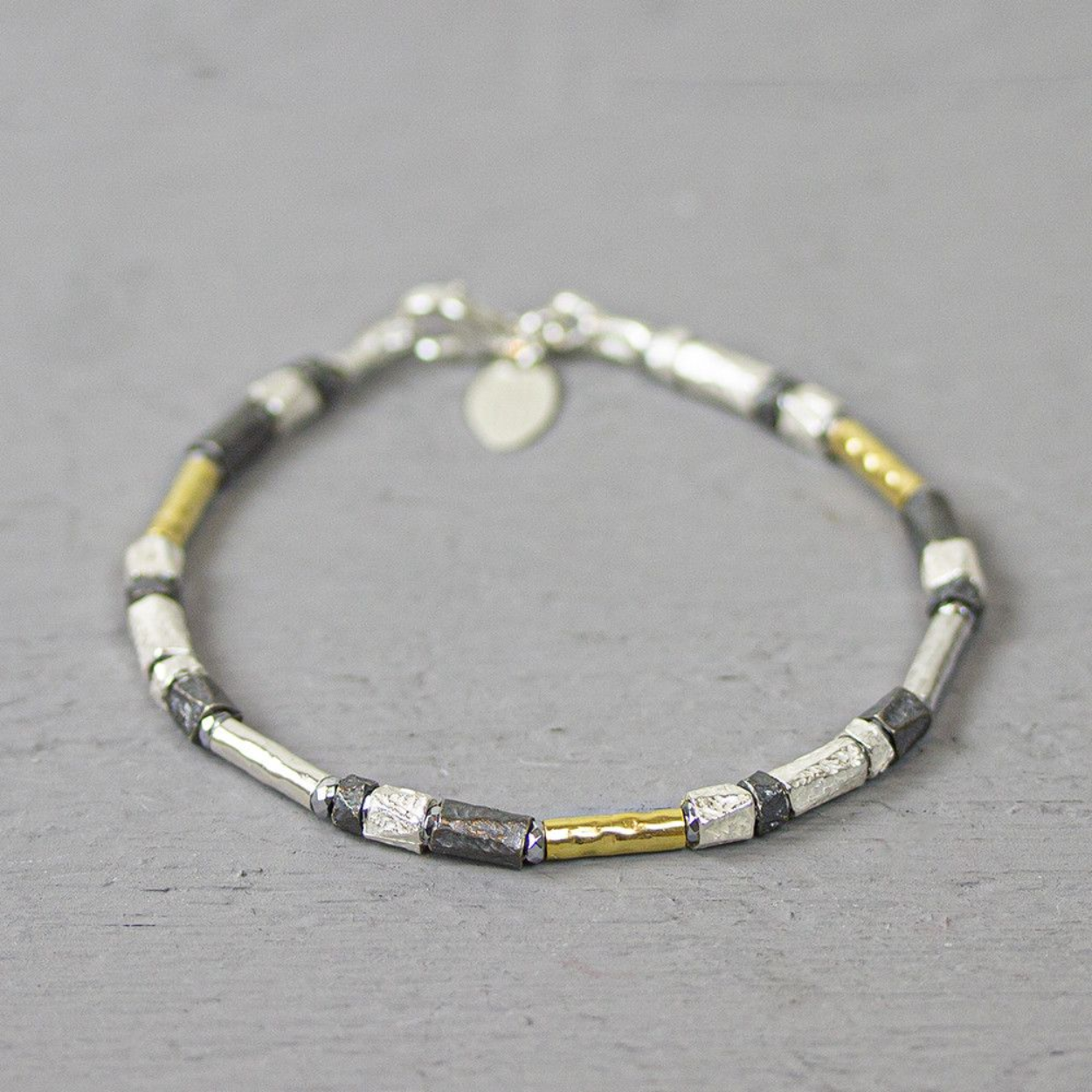 Fantasiearmband van Jéh Jewels. Deze armband is een combinatie van de karakteristieke kleuren van Jéh: geoxideerd en wit zilver en goldfilled. De armband bestaat uit kleine buisjes van 4mm breed en is 19 cm lang.
