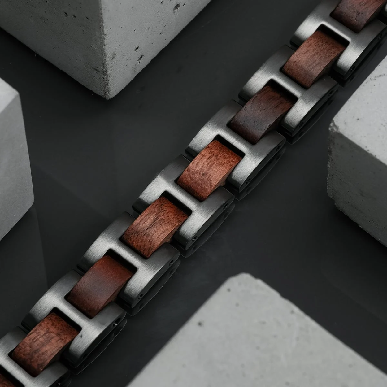 Het eenvoudige, elegante samenspel van 12 mm brede grijze roestvrijstalen schakels en elementen van hoogwaardig notenhout overtuigt door zijn eenvoud. De Acoustic Bandlet nestelt zich vederlicht om uw pols en wordt uw trouwe metgezel in het dagelijks leven.