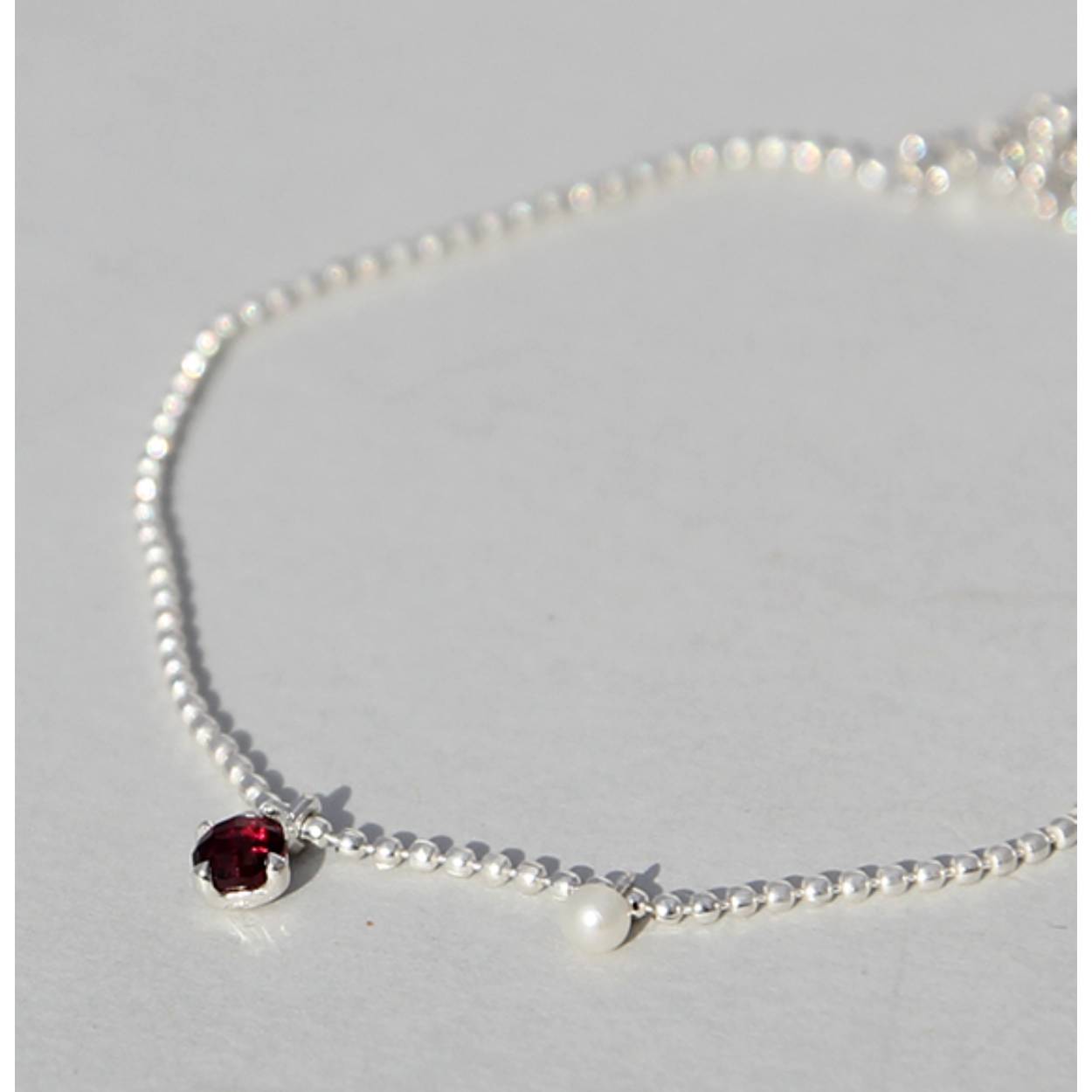Zilveren armband met Rhodoliet en zoetwaterparel.
lengte 18.5 cm