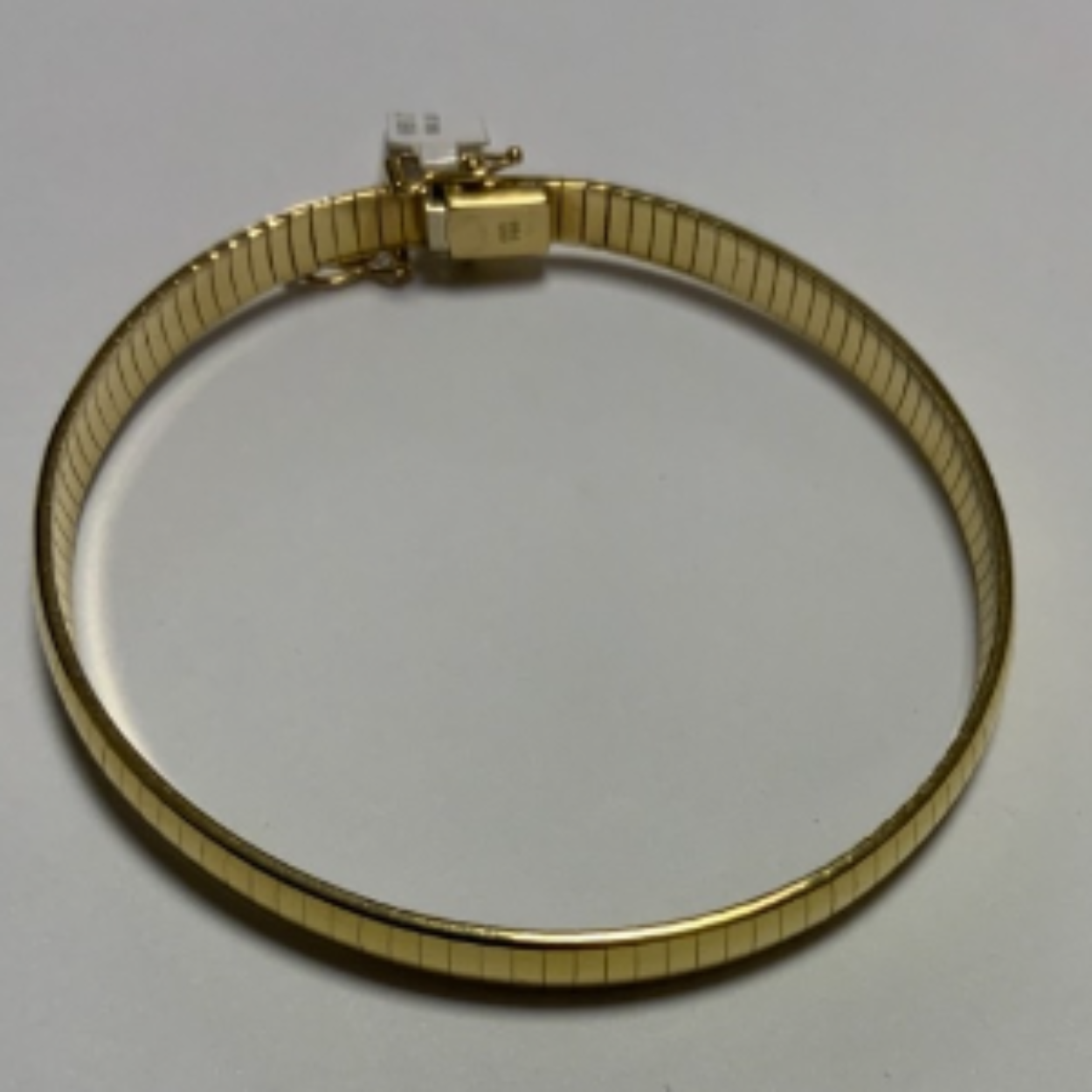 Goud omega armband 21 cm met baksluiting en 2x vh8.
Breedte; 6 mm