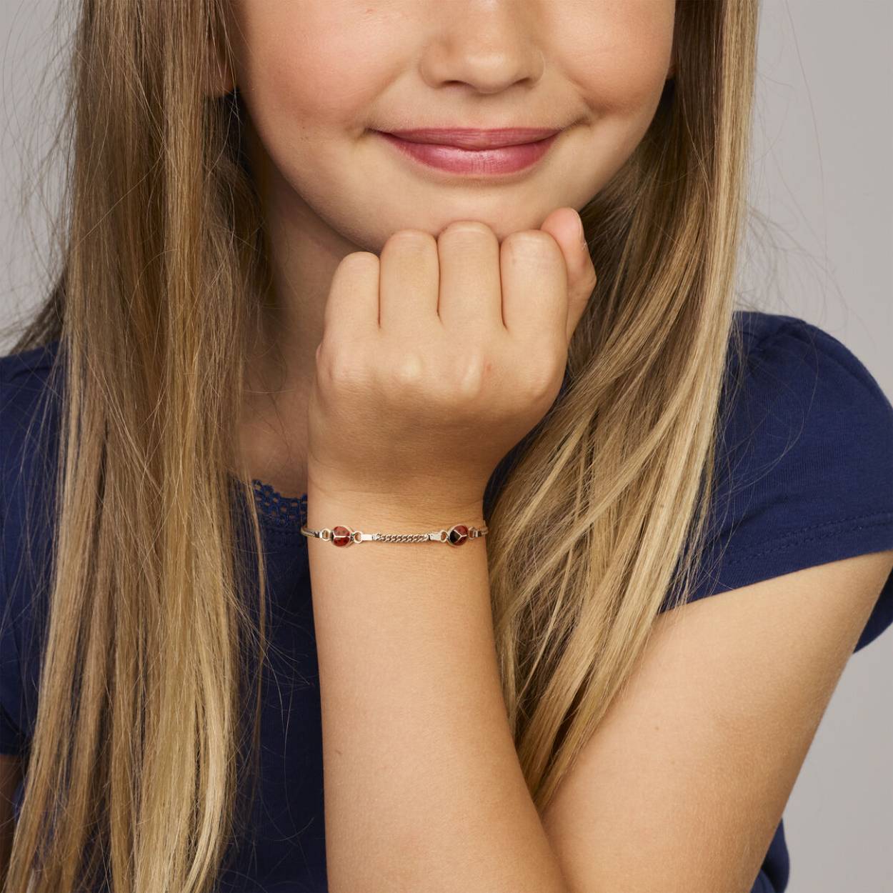 Zilveren kinderarmband met lieveheersbeestjes.