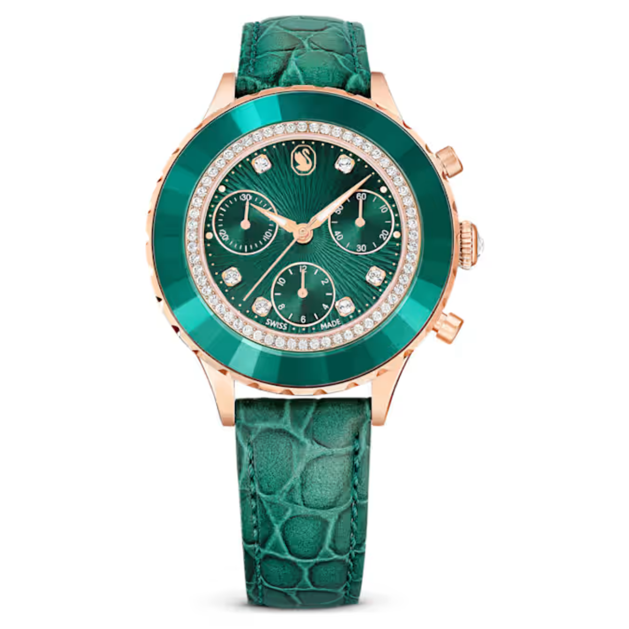 Dit groene chronograafhorloge vormt een perfecte combinatie van expertise op het gebied van horlogerie en Swarovski’s savoir-faire. De ronde kast van 37 mm heeft een roségoudkleurige afwerking en is voorzien van de kenmerkende facetgeslepen kristallen lunette met een cirkel van heldere pavé. Onder het mineraalglas is de guilloché wijzerplaat voorzien van het zwaanlogo ter hoogte van de 12, wijzers met LumiNova-coating en drie chronograaftellers om afzonderlijk uren, minuten en seconden bij te houden. Zes heldere kristallen dienen ter markering en ook op de kroon prijkt een kristal. Dit horloge van Zwitserse makelij is waterdicht tot 50 meter en wordt gedragen op een groene band van Italiaans kalfsleder met krokodilprint en een snelsluiting.