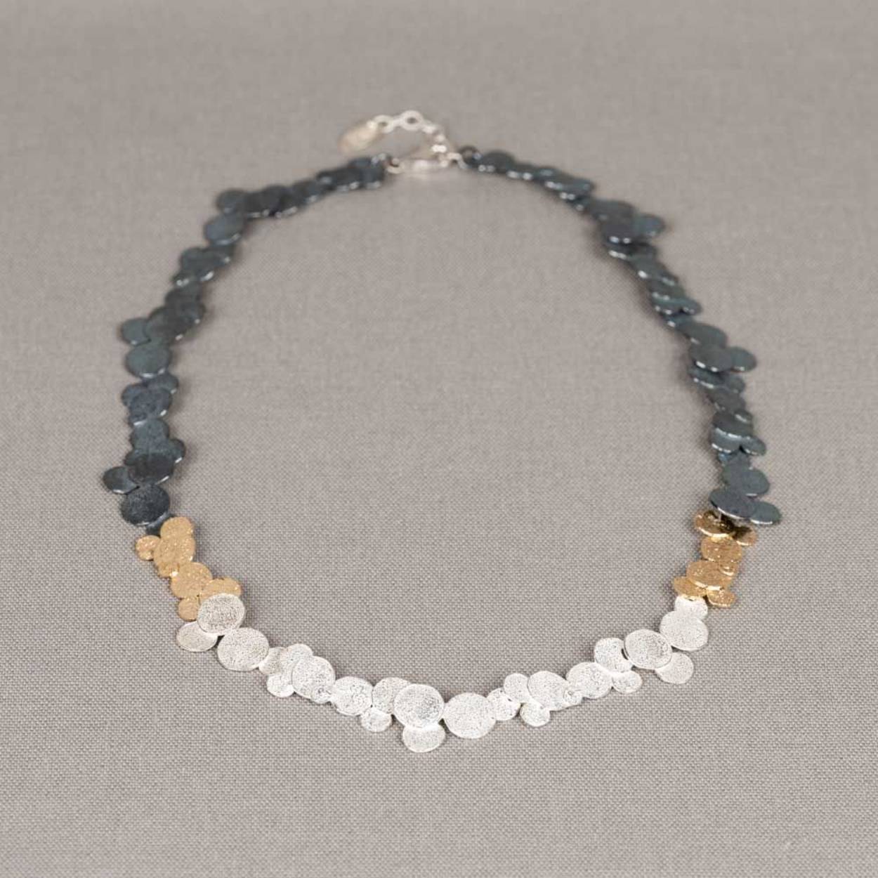 Collier gemaakt van 925 sterling zilver, geoxideerd zilver en zilver verguld. Door deze 3 materialen ontstaan ook de 3 kenmerkende kleuren van Jéh. De ronde schakels doen ons denken aan wolken. Combineer dit collier met de bijpassende armband voor een complete look!