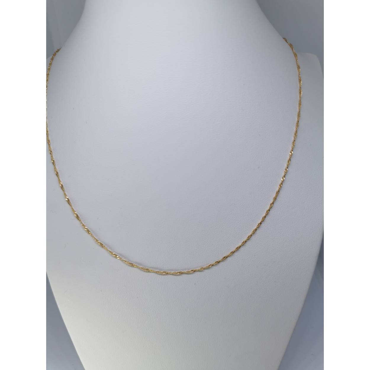 Een Singapore ketting bestaat uit een reeks platte diamand geslepen ruitvormige schakels. Vervolgens worden deze ruitvormige schakels gedraaid en afgeplat om een ketting te vormen. Dit proces resulteert in een ketting met schakels die licht reflecteren vanuit verschillende hoeken, waardoor de ketting een sprankelend uiterlijk krijgt en een aangename natuurlijke ronding. 
Leuk te combineren met een gouden hanger uit onze assortiment!