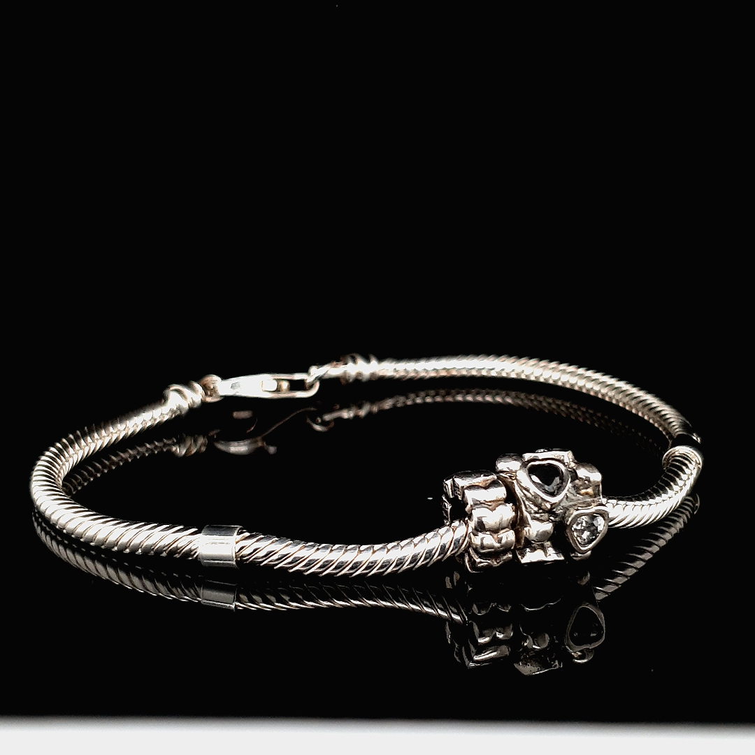 Zilveren armband met massieve bedel met zwarte en witte zirkonia hartjes. 
Lengte armband 18, 19, 20 en 21 cm