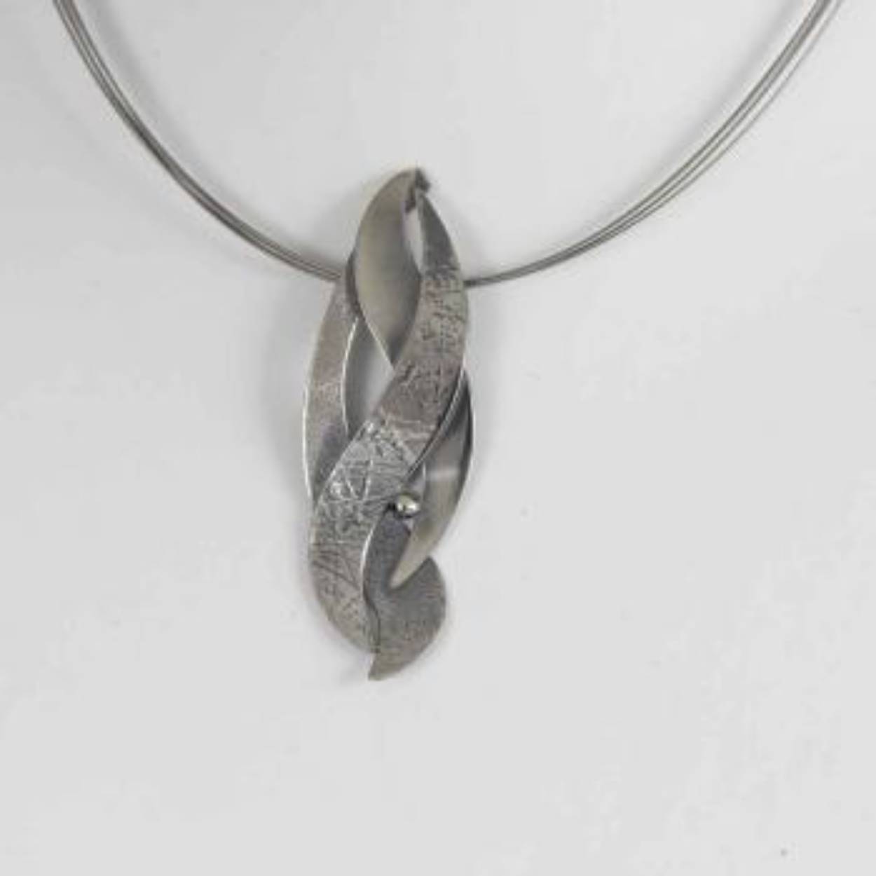 Buttner Schmuck handgemaakte sieraden vervaardigd in een klein atelier uit de Harz, zilveren hanger en staaldraadcollier.