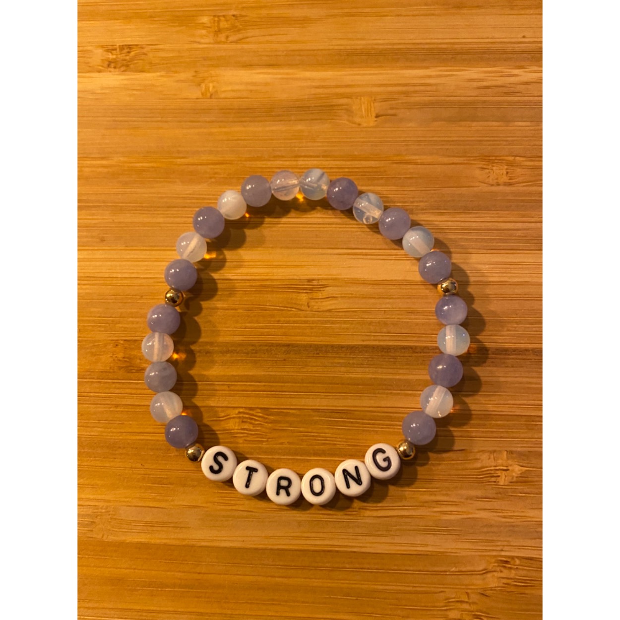 Lief armbandje met positieve tekst. Paarse en witte agaat en gold-plated ballen. Dit geschenkje is belangrijk voor jezelf om jezelf eraan te herinneren dat je Sterk bent.
 Je wordt blij als je het krijgt en even blij als je het weggeeft. Armband kan op aanvraag met elke positieve tekst gemaakt worden( max 7 letters)