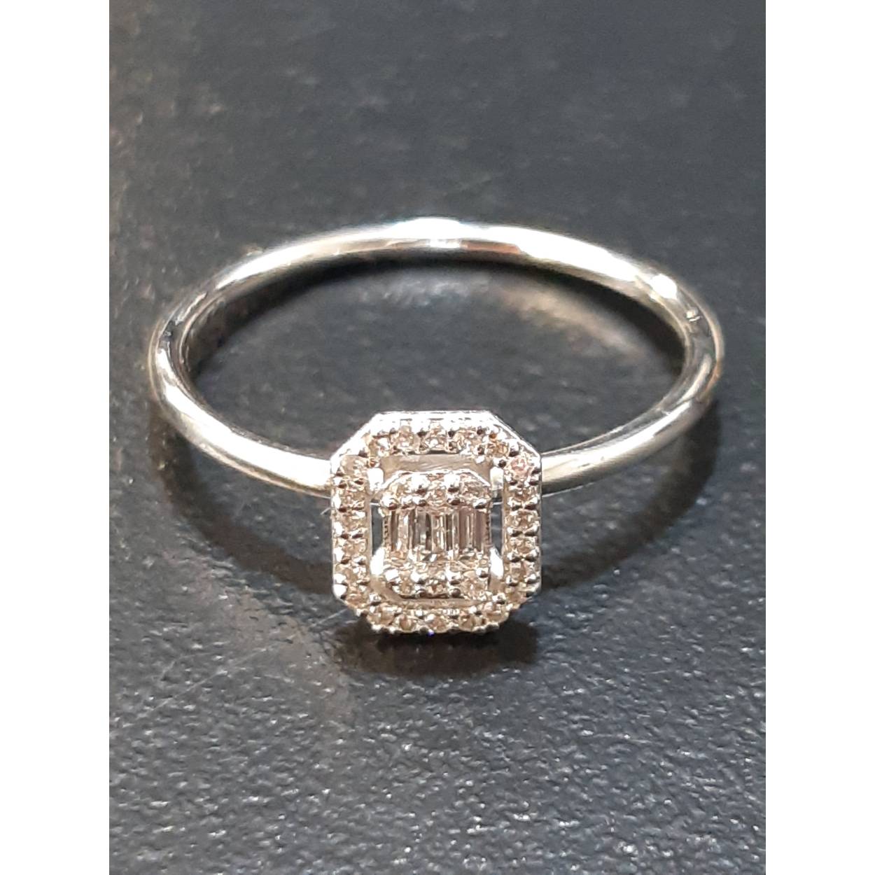 De Diamant ring BREA-0002809 is een elegante gouden ring (14kt) met diamanten van 0.08 f si en 0.04 bg, in baguette slijpvorm. De ring is glanzend wit en maat 54. Draag hem als verfijnd accessoire bij zowel formele als informele gelegenheden voor een vleugje luxe. Perfect voor dagelijkse elegantie of speciale momenten.