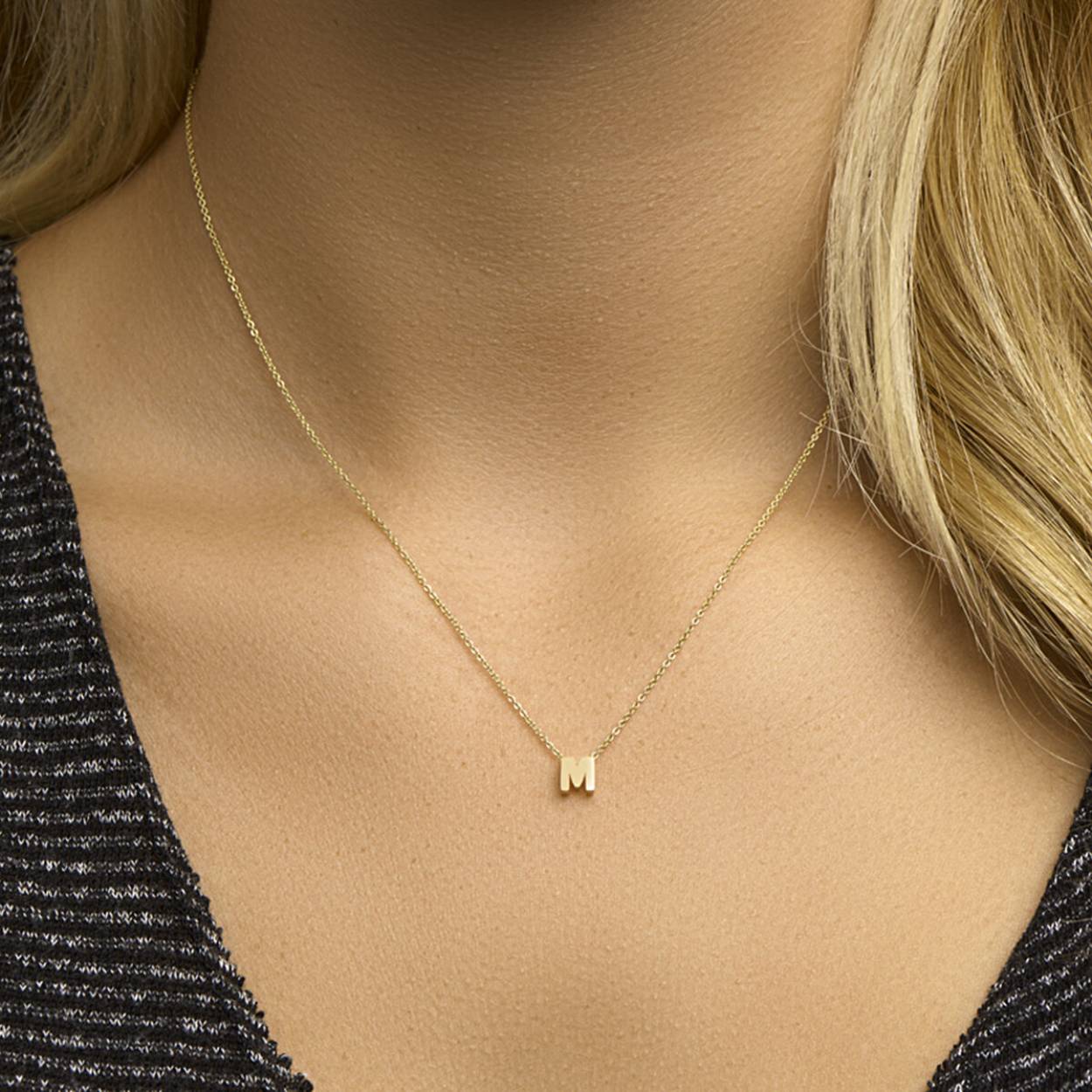 De hanger met de letter M, is een prachtige gouden hanger. Deze gouden hanger is speciaal ontworpen als een stijlvolle kettinghanger. Met een gewicht van 0,42 gram en een glanzende afwerking is het een verfijnde toevoeging aan elke outfit. Draag hem aan een fijne ketting voor een elegante look.