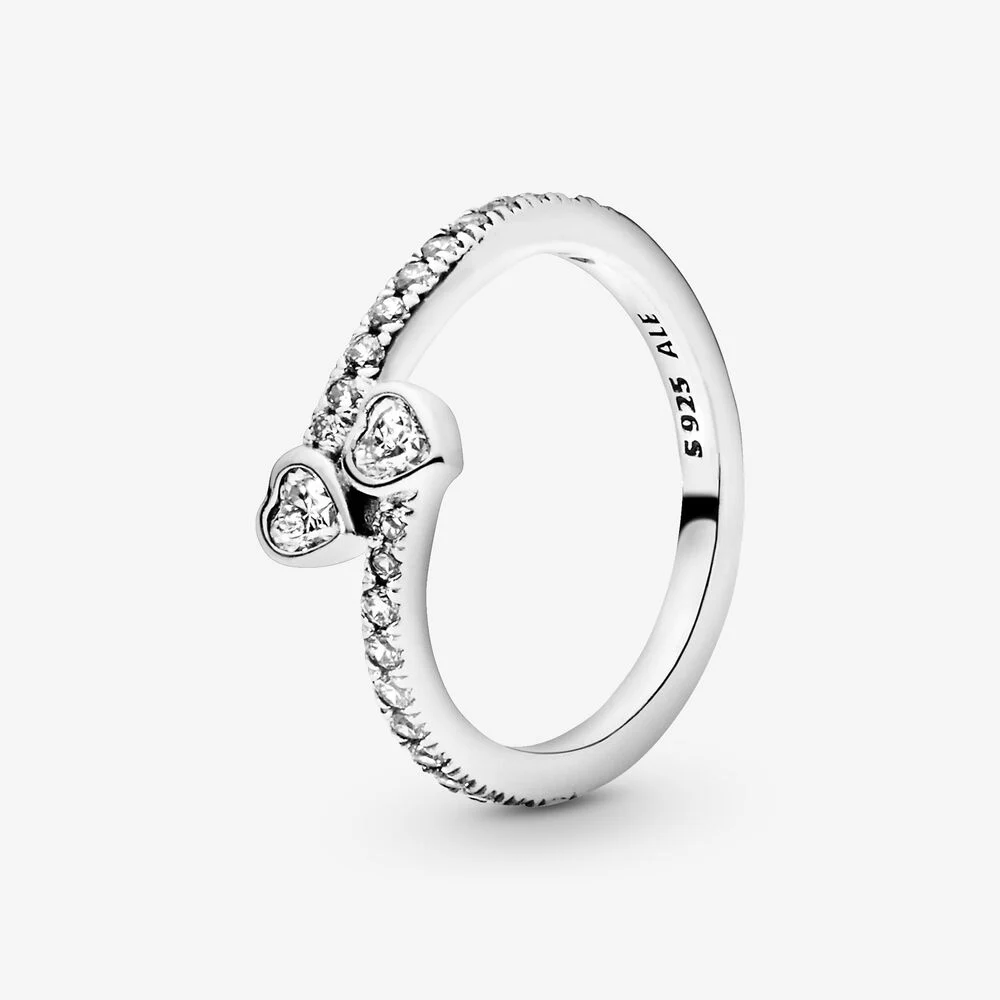De twee met elkaar verweven harten maken van deze schitterende ring het ultieme symbool van liefde. Deze met de hand afgewerkte Pandora ring met hartjes is gemaakt van sterling zilver. Hij is gezet met glinsterende zirkonia's en afgewerkt met twee hartvormige steentjes, die staan voor liefde en vriendschap. Het is het ideale romantische gebaar voor Valentijnsdag, verjaardagen en jubilea, of gewoon om te zeggen 'Ik houd van jou'.