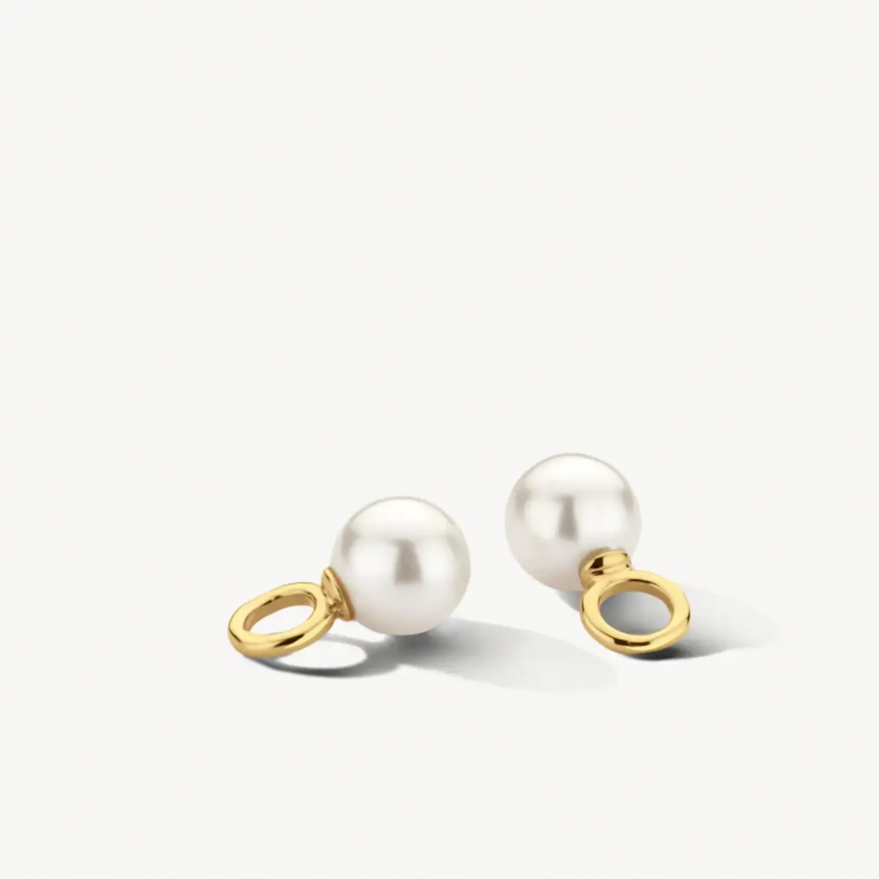 De Swarowski-parels met een doorsnede van 6 mm geven deze oorbedels een klassieke uitstraling. De bedels zijn gemaakt van 14k geelgoud. Je schuift ze zo om een gladde oorring of om oorringen met pavé gezette zirkonia’s van maximaal 2,9 mm doorsnede.