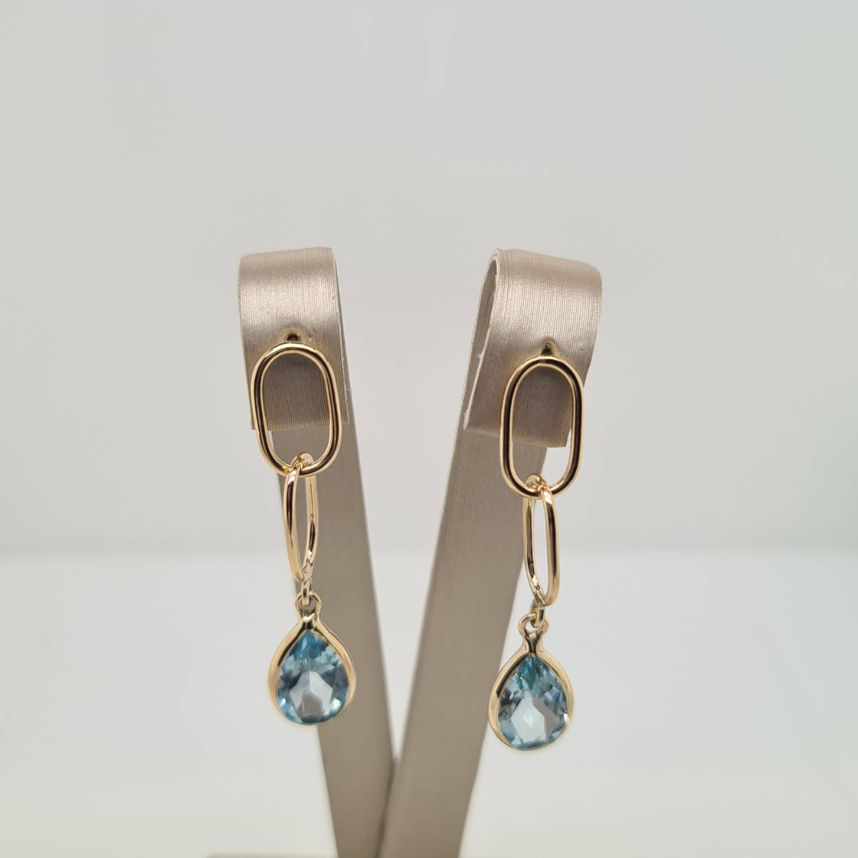 Prachtige 14 karaat gouden oorsieraden met een blauw topaas.  
