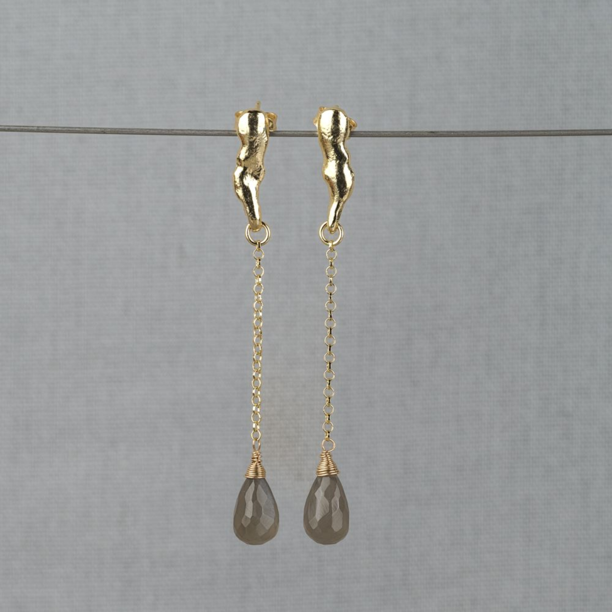 Oorstekers sierlijk gemaakt van zilver verguld met daaraan een hanger van Grijze Maansteen. Grijze Maansteen heeft een sterke connectie met de maan en vrouwelijke energie. Lees alles over deze edelsteen via onderstaande button. Combineer deze oorbellen met een collier, ring of armband van Jeh Jewels!