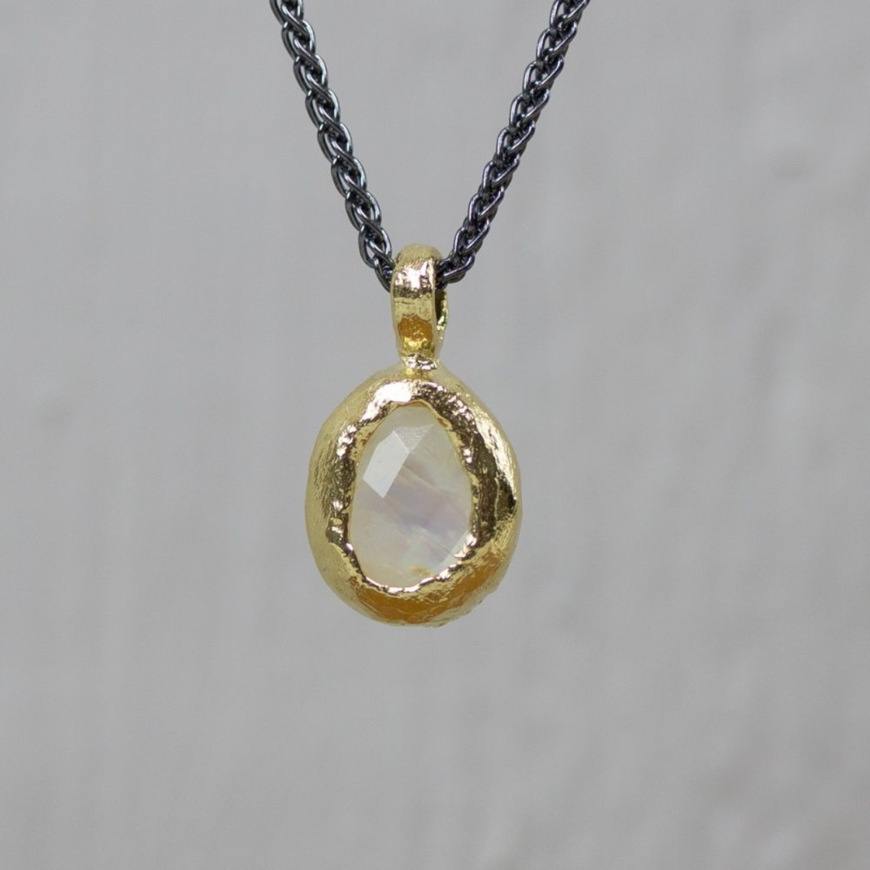 Collier gemaakt van 925 sterling zilver aan het collier hangt een gefaceteerde maansteen omsloten met zilver verguld. 