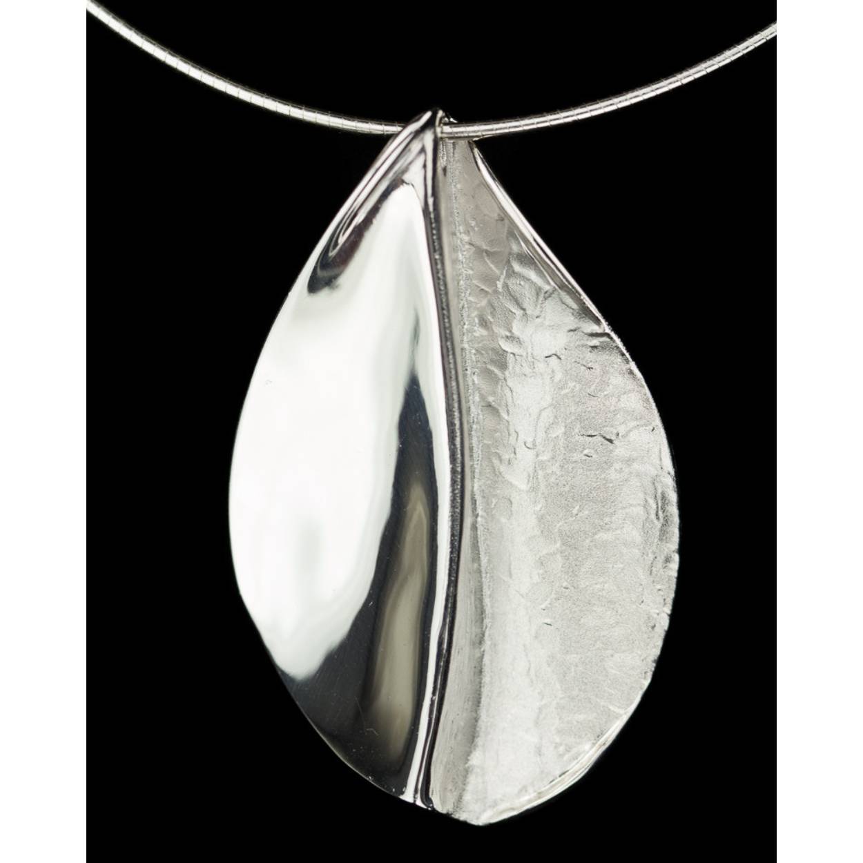 Fraaie hanger van Sanjoya in zilver. De vorm is een gevouwen blad met een gepolijste en een gematteerde zijde. Er zijn bijpassende oorsieraden en een ring leverbaar om de set compleet te maken.