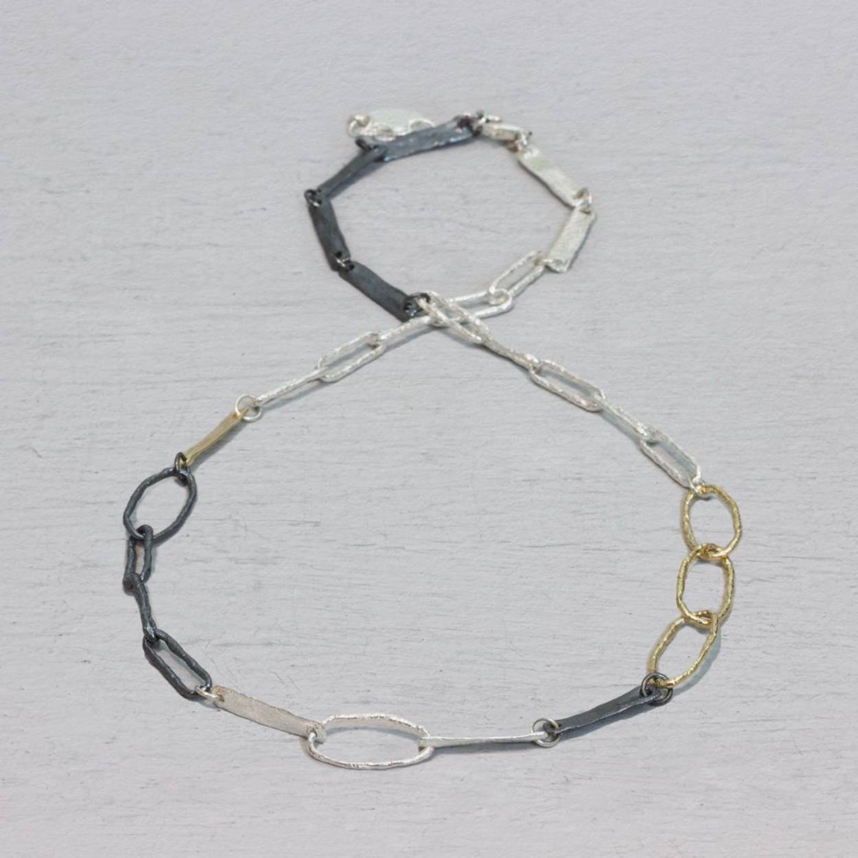 Collier met lussen en schakels in drie kleuren van Jeh Jewels. Gemaakt van 925 (geoxideerd) sterling zilver en zilver verguld. Combineer dit prachtige collier met bijpassende oorsieraden, een ring of armband.