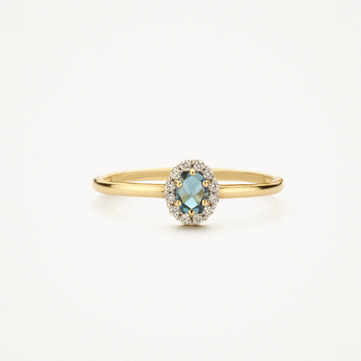 Deze 14k geelgouden ring springt in het oog door helderblauwe topaas omringd door zirkonia. De band heeft een doorsnede van 1,3 mm en de ring is prachtig te combineren met een of meer andere (aanschuif)ringen uit onze collectie.