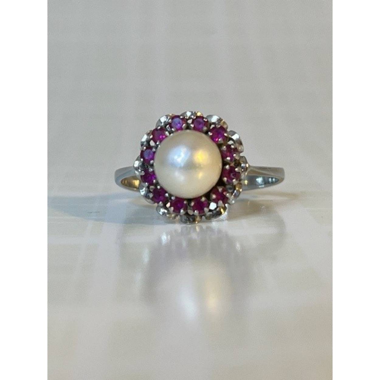 Mooie 14 karaat witgouden ring met parel en 12 robijnen. De scheen is 2 mm breed en de kop van de ring is 11mm.